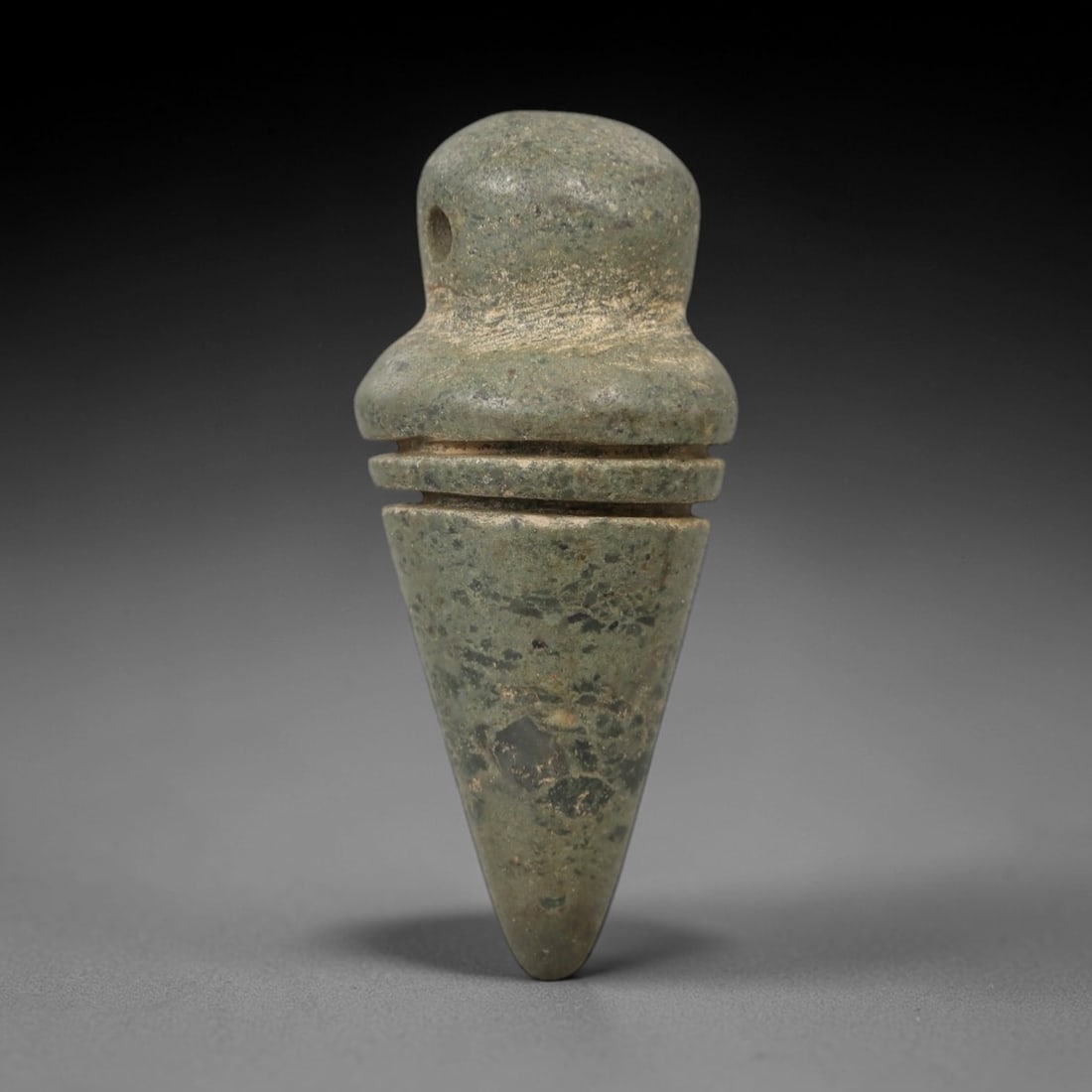 Ancient Stone Conical Amulet - Near Eastern Ritual Figurine, 8AG: This amulet is carved from a single piece of mottled green stone, exhibiting a granular texture with subtle ochre patina and natural mineral inclusions across its surface. The form is a stylized conic