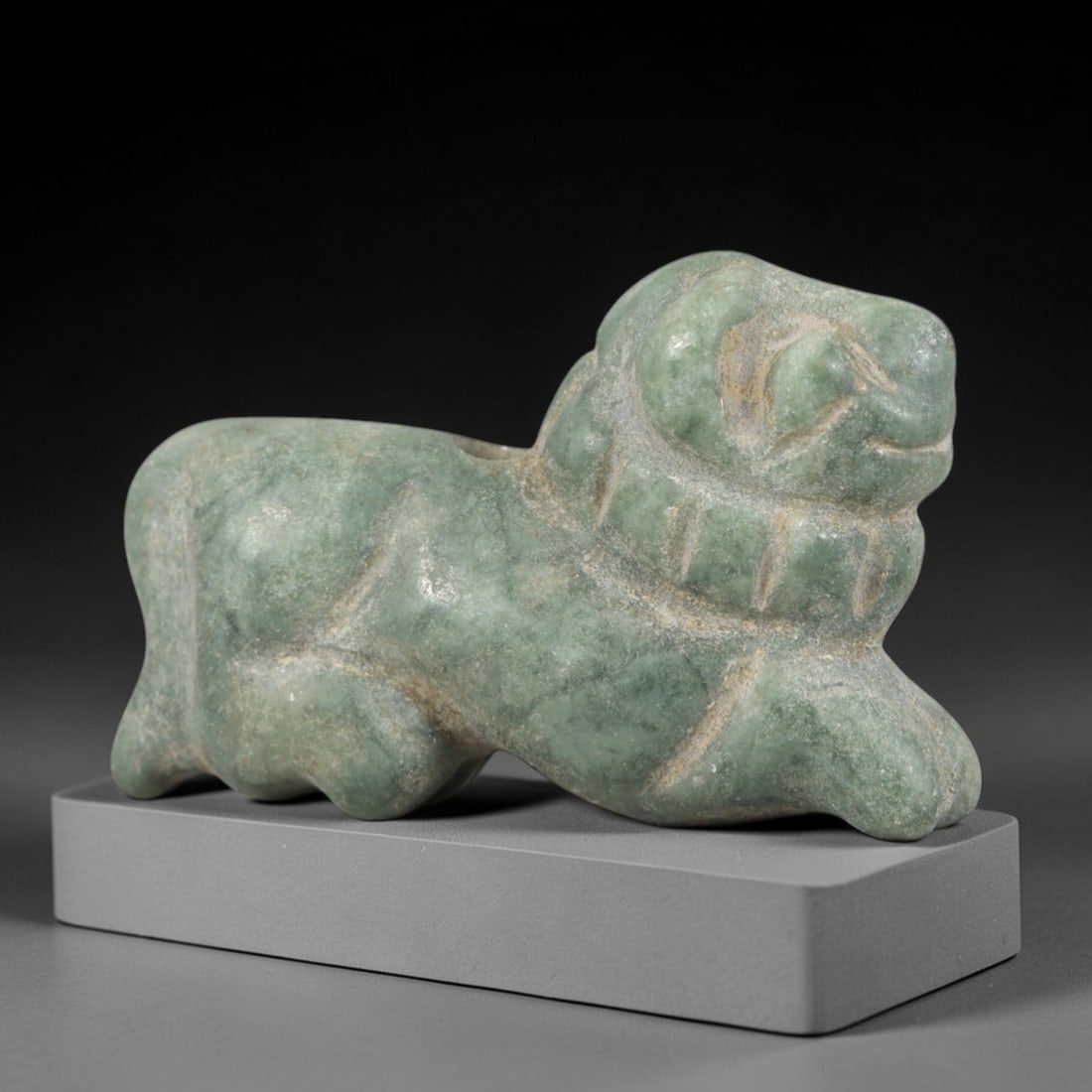 Ancient Green Stone Feline Amulet - Near Eastern Figurine, 35AR: This artifact is carved from a mottled green stone, exhibiting a weathered, matte finish with subtle mineral variations and faint surface wear consistent with age. The form is a stylized recumbent fel