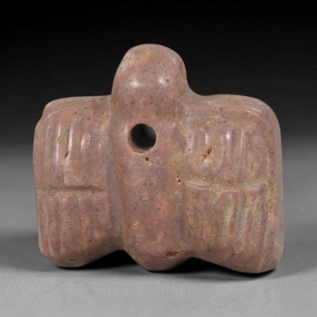 Ancient Stone Bird - Near Eastern Amulet Figurine, 37AP: This artifact is carved from pinkish-brown stone with a weathered, earthy patina and subtle mineral inclusions, exhibiting stylized avian features consistent with ancient Near Eastern stoneworking tec