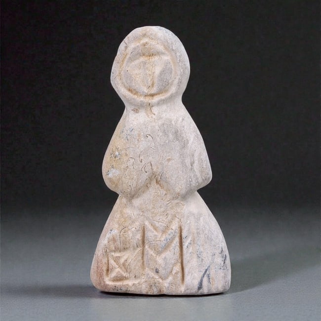 A Medieval Stone Anthropomorphic Figure, Circa 12th-14th Century, 80FJ: Carved from light-toned stone with a granular texture and areas of surface wear, the figure is rendered as a standing anthropomorphic form with a simplified, frontal orientation. The head is rounded a