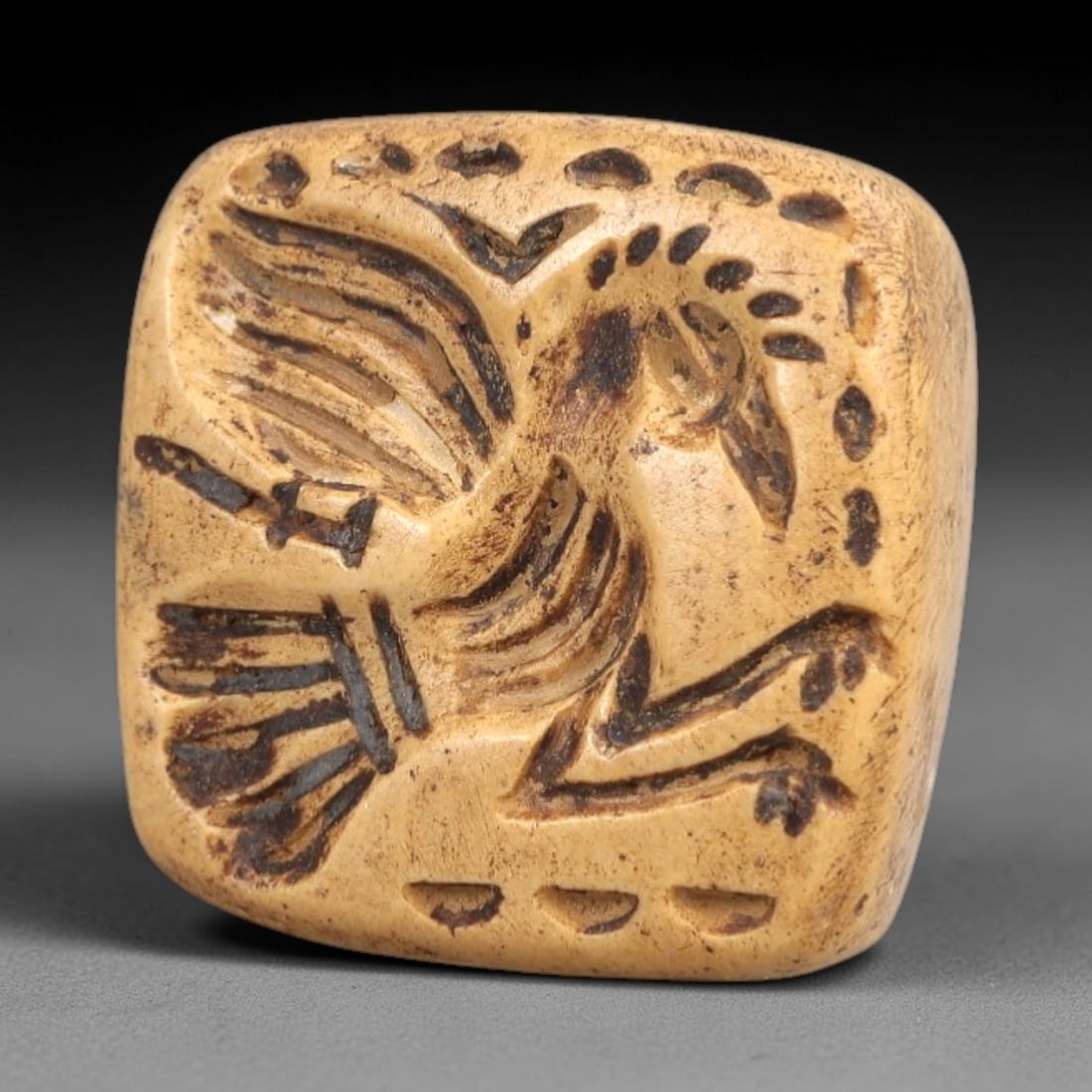 Ancient Stone Conoid Stamp Seal - Near Eastern Bird Motif, 71AL: Carved from a light tan, fine-grained stone, this diminutive conoid stamp seal features a detailed avian motif, likely a falcon or eagle, with outstretched wings and stylized tail feathers, executed i
