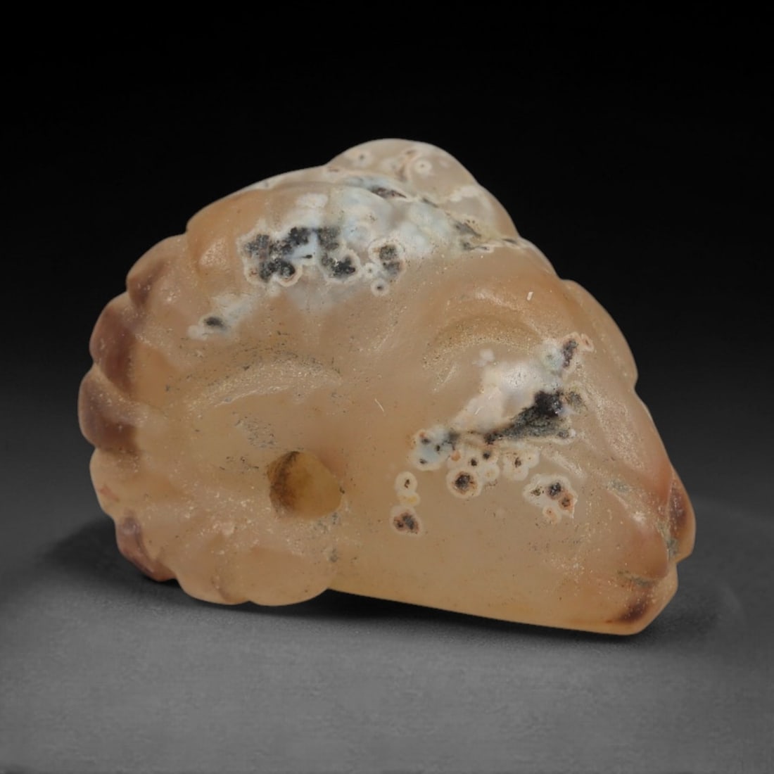 Ancient Agate Ram's Head Amulet - Near Eastern Figurine, 49XS: Carved from warm, translucent peach agate with striking natural inclusions of creamy white, deep red-brown, and black dendritic patterns, this amulet is formed as a stylized ram's head with incised li