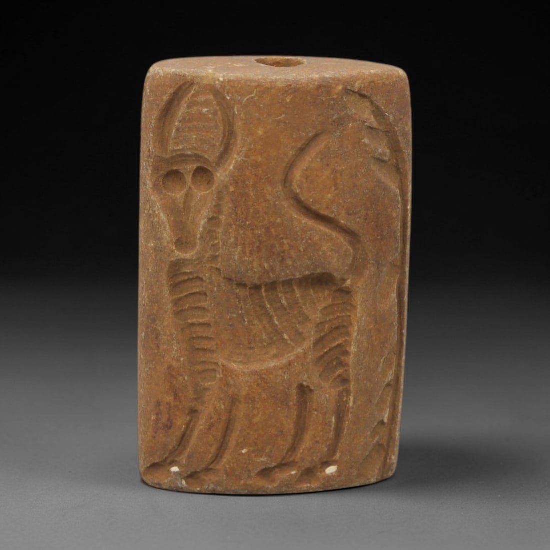 Ancient Steatite Amulet - Near Eastern Double Convex Stamp Seal, 14ZQ: Carved from steatite, this ancient Near Eastern double convex stamp seal features a stylized animal motif with linear detailing, typical of early glyptic art. The compact form exhibits a smooth, aged