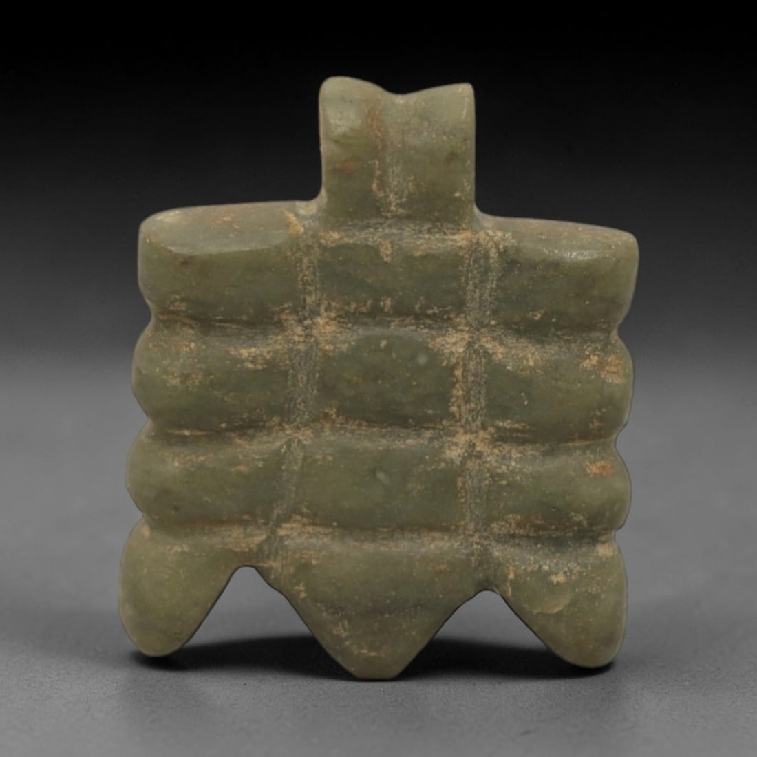 Ancient Stone Fly Amulet - Near Eastern Animal Pendant, 61XQ: This amulet is carved from a smooth, pale green stone, shaped into a stylized fly form with a raised rectangular suspension loop at the top, confirming its use as a wearable protective charm. The body