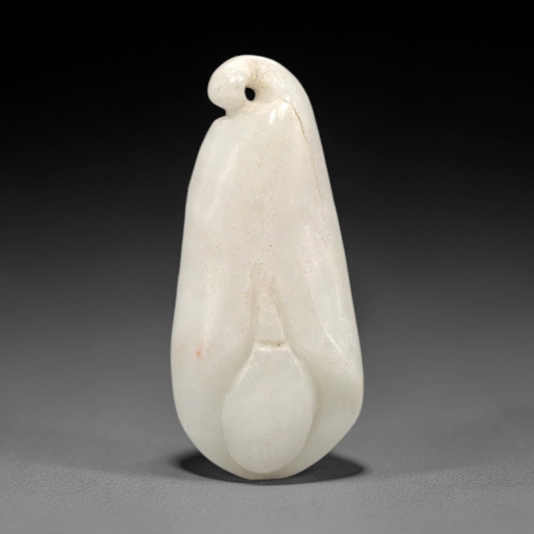 A Chinese Jadeite Jade Floral-Form Pendant, 20th Century, 79FR: Carved from opaque white jadeite jade with minor faint orange inclusions, the pendant is shaped in the form of a stylized flower bud. It features a smoothly polished, rounded body with subtle indentat