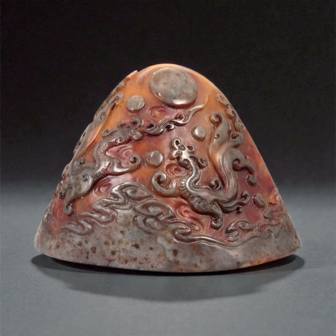 A Chinese Shoushan Stone Stamp Seal, 20th Century, 1FA: Carved from variegated Shoushan stone displaying tones of reddish-brown, russet, and grey with natural mottling, the seal is worked with a tapering, irregularly domed upper section and a flat oval sea
