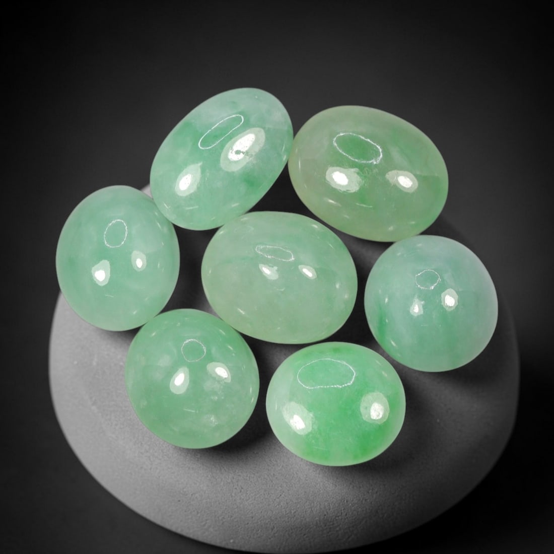 Natural Type A Jadeite Jade - Loose Cabochon Gemstone, 3AP: Crafted from natural Type A jadeite jade, these seven cabochons display a soft, translucent pale green hue with subtle tonal variations inherent to the material. Each stone is cut en cabochon with a s