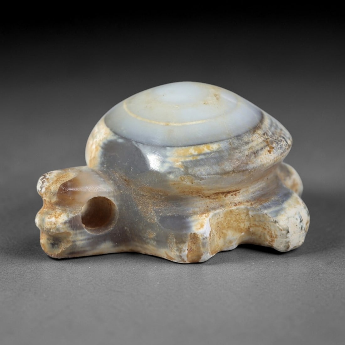 Ancient Agate Tortoise Amulet - Near Eastern Figurine, 48AR: This artifact is carved from banded agate, exhibiting a smooth, polished surface with natural concentric banding and faint surface wear consistent with age. The form is a miniature stylized tortoise a