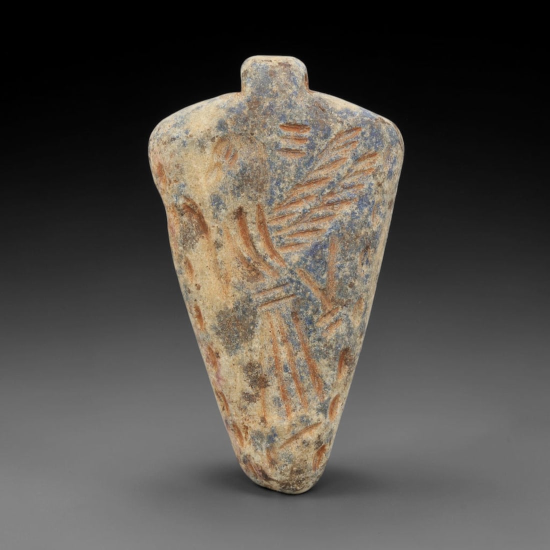 Ancient Lapis Lazuli Amulet - Near Eastern Figure, 97ZT: Carved from lapis lazuli, this amulet features a relief depiction of a stylized figure, rendered in the simplified glyptic tradition of the ancient Near East. Incised lines define the figure's form, w
