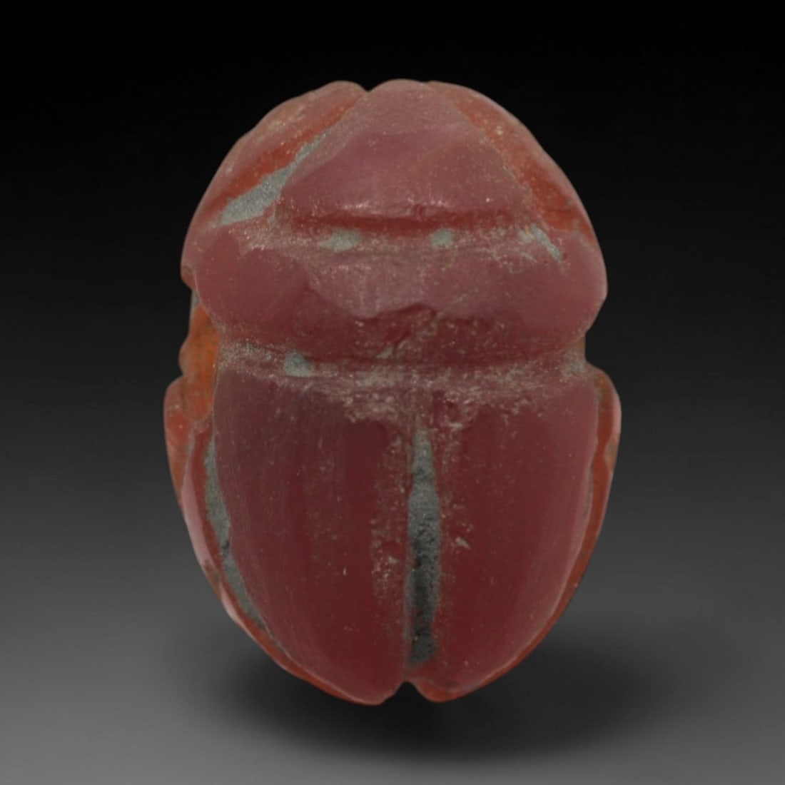 Ancient Carnelian Scarab - Egyptian Amulet Figurine, 100ZW: This amulet is carved from rich red carnelian, shaped in the form of a scarab beetle, a symbol of rebirth and protection in ancient Egyptian cosmology. The dorsal surface features incised lines deline