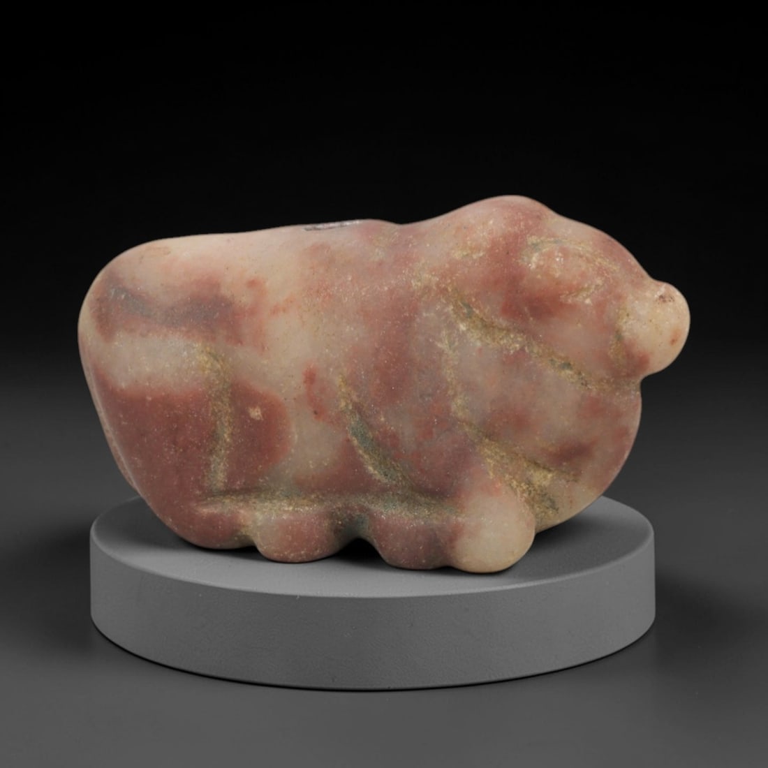 Ancient Red Stone Zoomorphic - Indus Valley Animal Figurine, 73XP: Carved from variegated red-and-pale stone, this miniature zoomorphic figurine depicts a stylized quadrupedal creature, likely a domesticated bovid or bull, a recurring motif in Indus Valley art. The f
