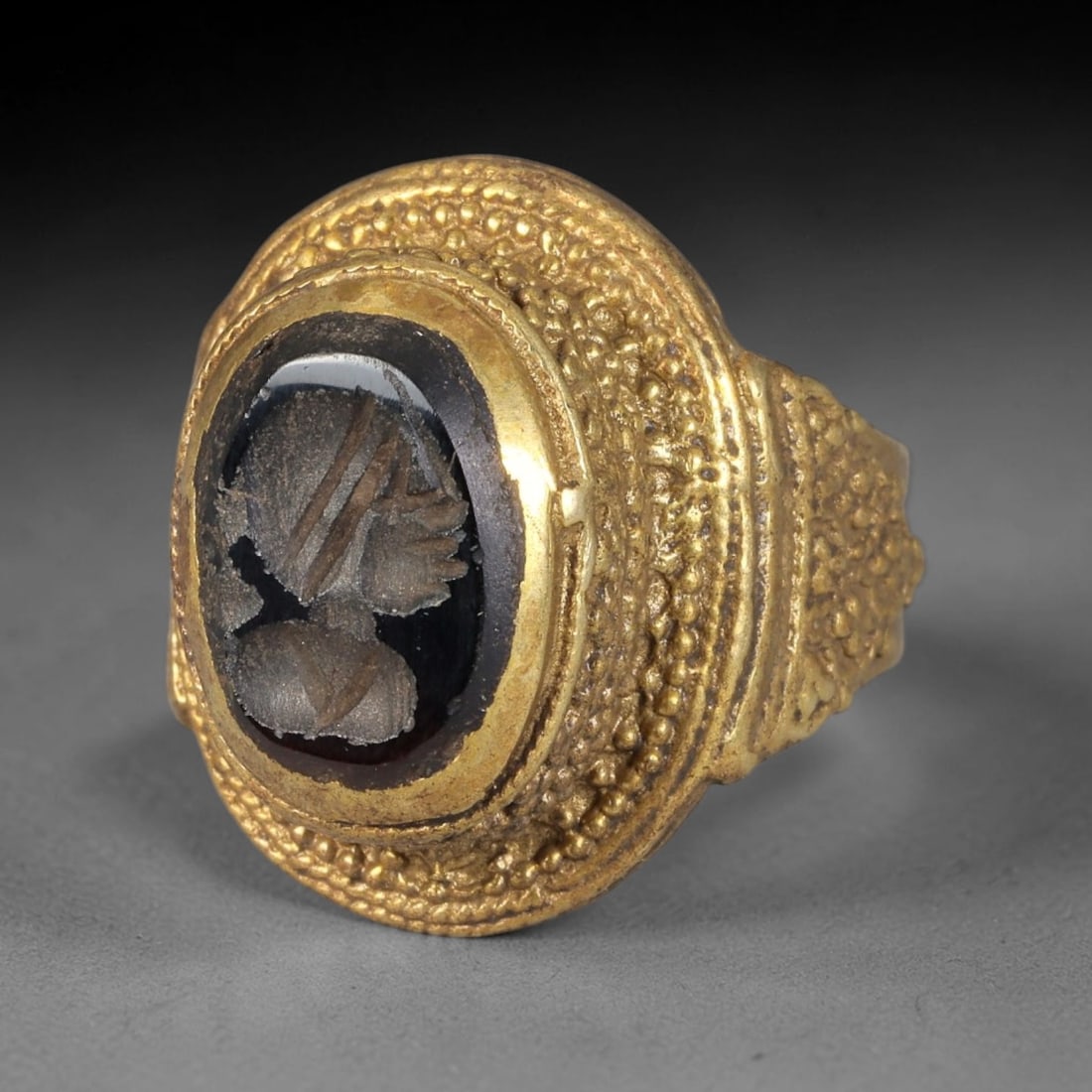 Antique Qajar Dynasty Garnet Portrait Intaglio Ring - Size 8 US, 75BA: Crafted from gilt brass with an ornate domed bezel, this ring features a carved garnet intaglio stone at its center, depicting an incised profile portrait motif characteristic of Qajar-era Persian sym