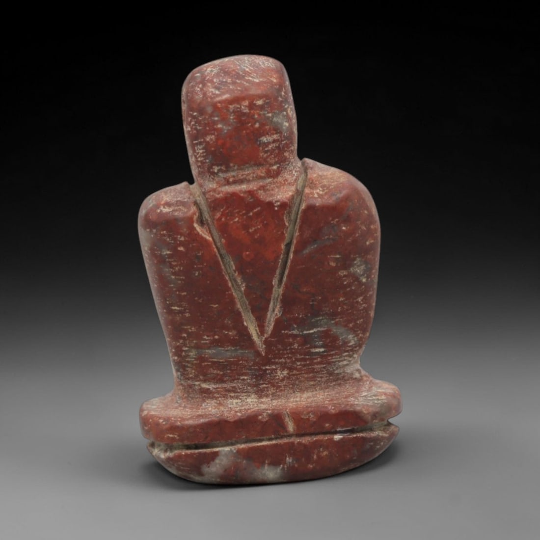 Ancient Near Eastern Stone Anthropomorphic Amulet - Carved Figurine, 22ZV: This amulet is carved from a rich, reddish-brown stone with natural veining, likely siltstone or a similar sedimentary rock, with incised linear details defining its stylized anthropomorphic form. The