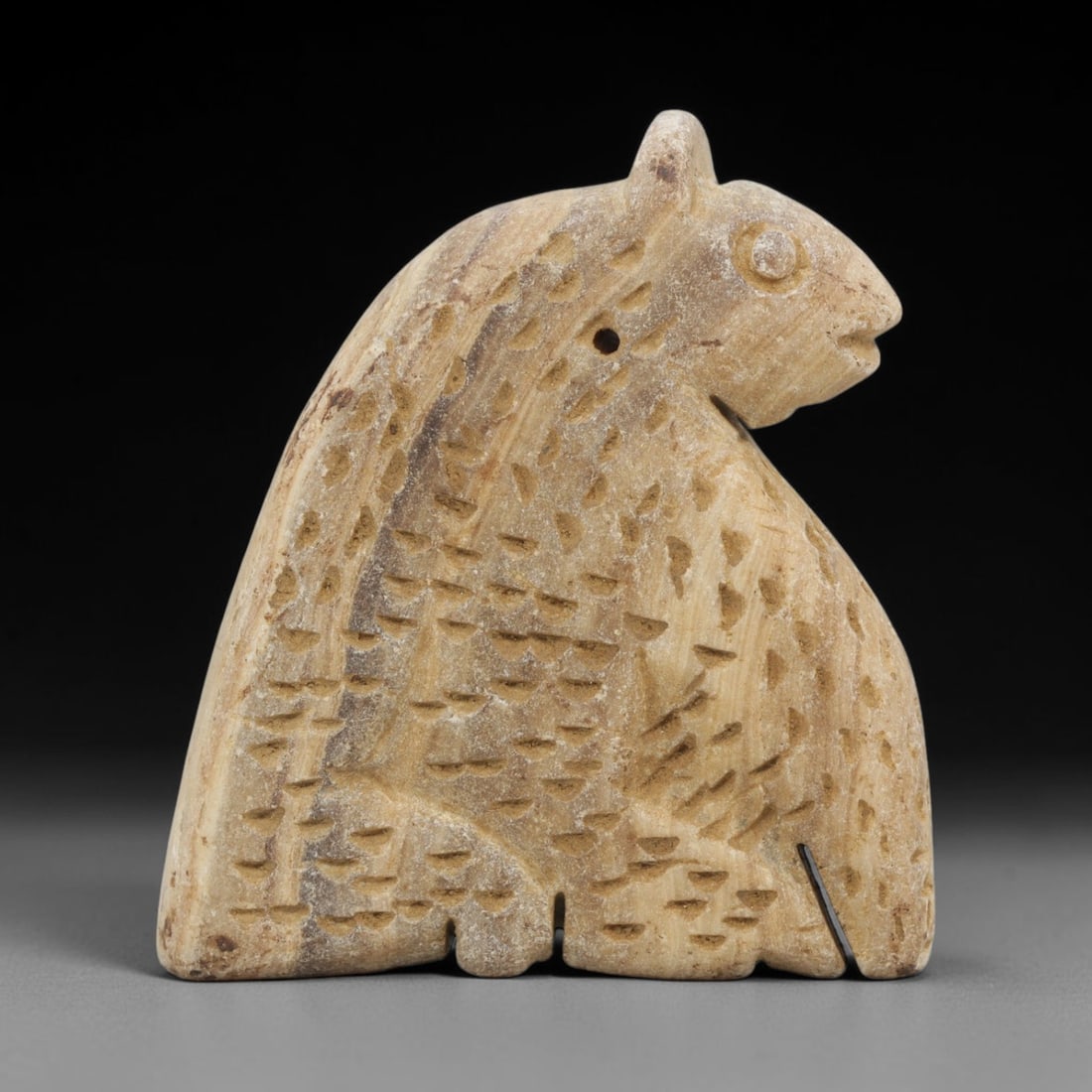 Ancient Stone Bear Amulet - Near Eastern Carved Figurine, 81ZT: Carved from light-colored hardstone, the amulet takes the form of a stylized bear, rendered in flat relief with extensive incised decoration. The body is covered with impressed dot motifs to represent