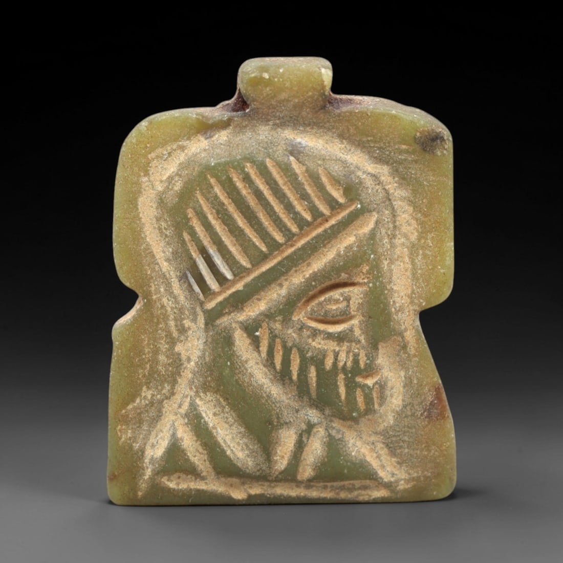 Ancient Sasanian Serpentine Amulet - Profile Relief Figurine, 15AK: Carved from smooth, olive-green serpentine, this rectangular amulet features a low-relief profile of a bearded Sasanian noble or deity, with incised linear details defining the stylized headdress, fac