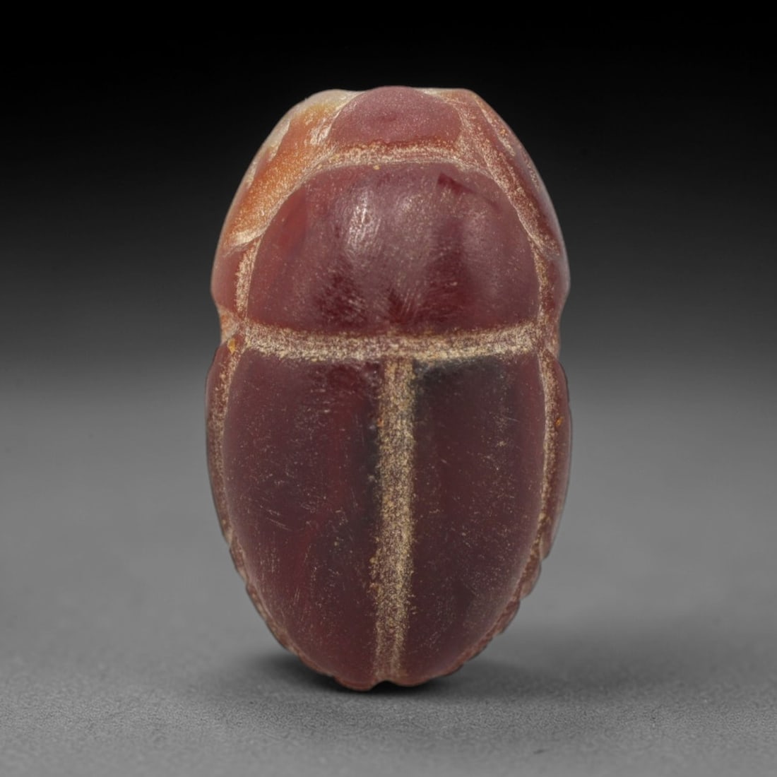 Ancient Carnelian Scarab - Egyptian Amulet Bead, 77XS: This amulet is carved from rich deep red carnelian, exhibiting natural translucency and warm hue characteristic of ancient Egyptian glyptic craftsmanship. The form is a classic scarab beetle, with def