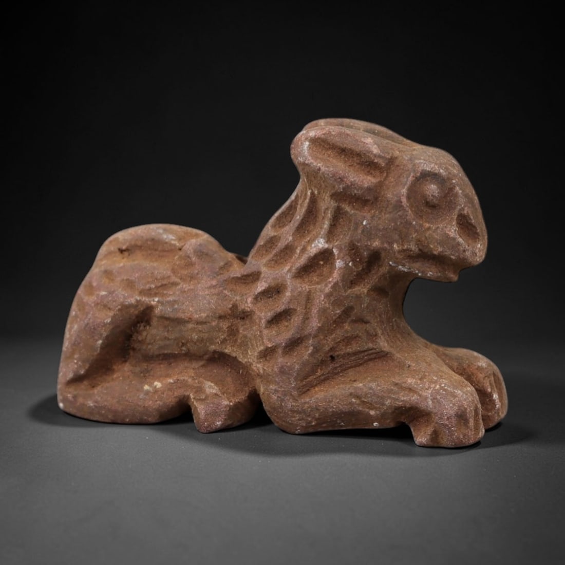 Ancient Limestone Feline Amulet - Miniature Relic, 3AH: Carved from limestone, this ancient feline amulet features a stylized, naturalistic rendering of a recumbent feline with detailed facial features and subtle body detailing. The stone exhibits a muted