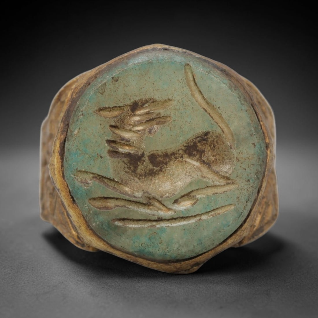 Antique Qajar Dynasty Faience Intaglio Ring - Size 9 US, 90ZX: Crafted from gilt metal with a rounded bezel, this ring features a carved faience intaglio stone at its center, incised with a stylized quadruped motif characteristic of Qajar-era Persian symbolic car