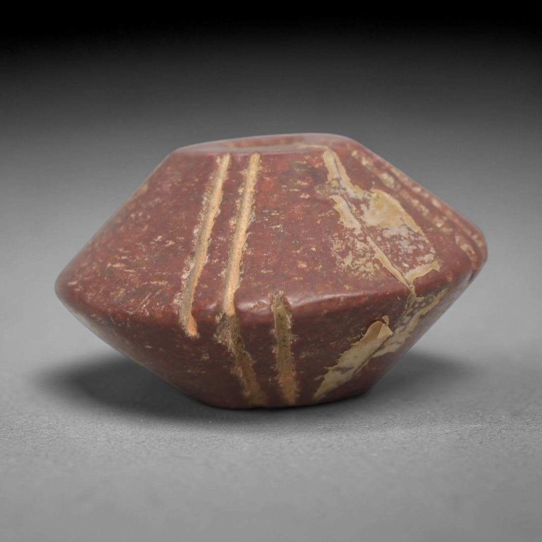 Ancient Near Eastern Red Stone Sun Disk Amulet - Carved Bead Figure, 40ZV: This amulet is carved from a rich, deep red stone with natural mineral veining and patination, likely brecciated jasper or red steatite, featuring a circular sun disk form. The piece is defined by a c