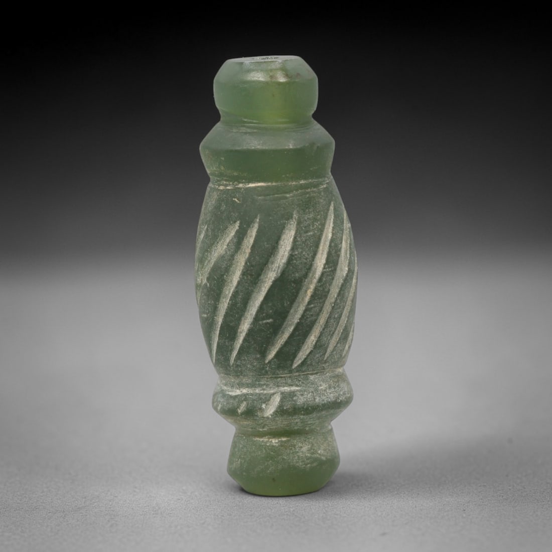 Ancient Serpentine Bead - Near Eastern Amulet Pendant, 78ZW: This amulet bead is carved from translucent green serpentine, shaped into an elongated cylindrical form with tiered collars at either end and diagonal incised lines across the central body. A central