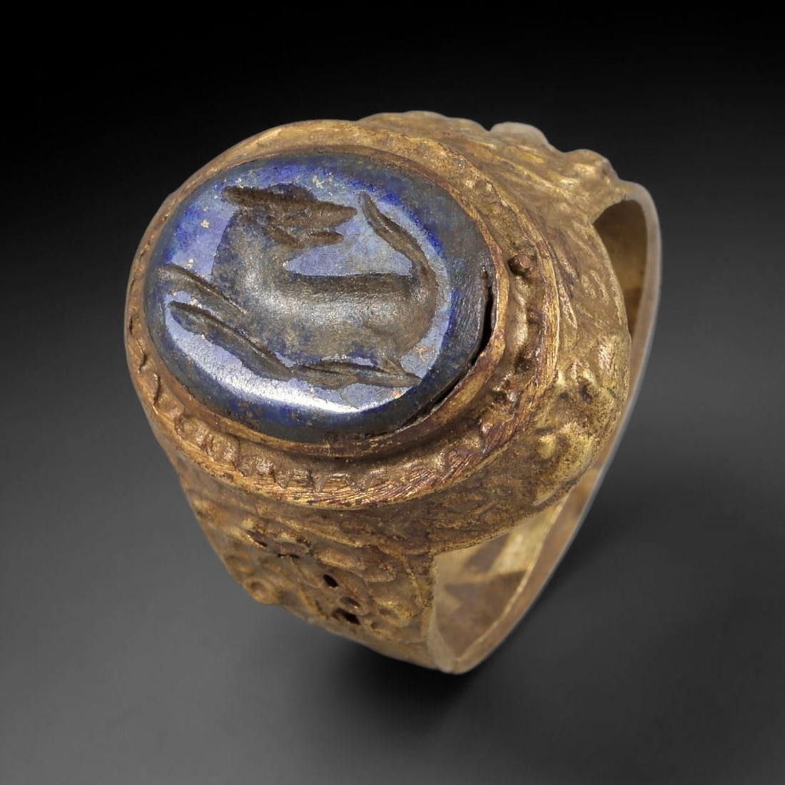 Antique Qajar Dynasty Lapis Intaglio Brass Ring - Size 8 US, 73BA: Crafted from brass, this ring features an oval lapis lazuli intaglio panel carved with a stylized quadruped, executed in the traditional Qajar style. The brass band displays ornate, textured metalwork