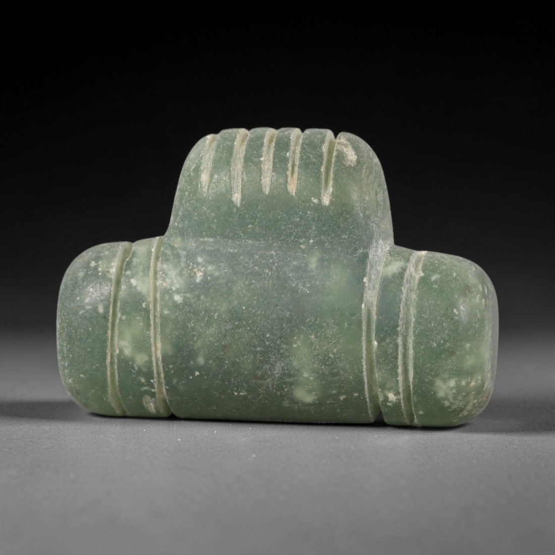 Ancient Serpentine Double-Barreled Amulet - Near Eastern Pendant, 42AR: This artifact is carved from pale, mottled green serpentine, exhibiting a smooth, matte finish with subtle natural inclusions and faint surface wear consistent with age. The form is a symmetrical doub