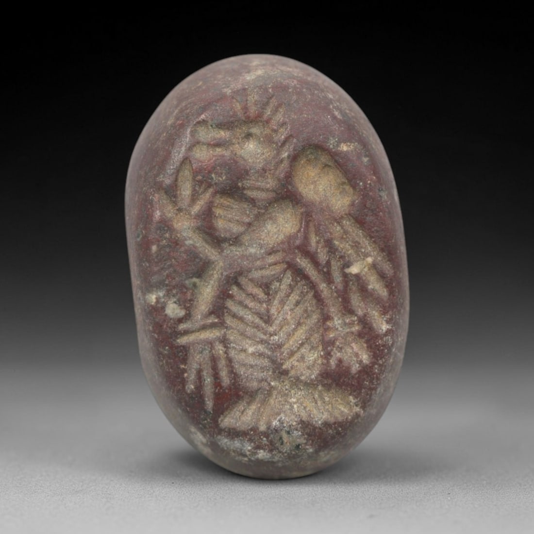 Ancient Stone Hemispherical Stamp Seal - Near Eastern Mythical Hybrid Figure, 95ZS: Crafted from dense, reddish-brown stone, this hemispherical stamp seal bears incised carving of a mythical hybrid figure, likely a bird-headed anthropomorphic being, with feathered body detailing, out