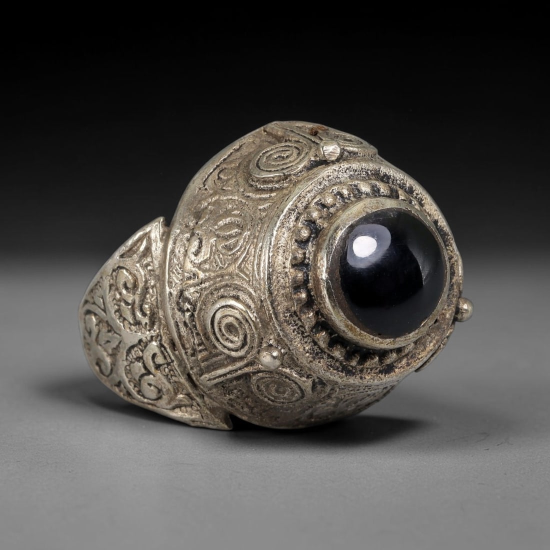 Antique Qajar Dynasty Silvered Black Stone Dome Ring - US Size 8, 65BA: This antique ring, crafted during the Qajar Dynasty of Persia, features a bold domed bezel centered with a polished round black stone cabochon, surrounded by intricate beaded granulation, spiral motif