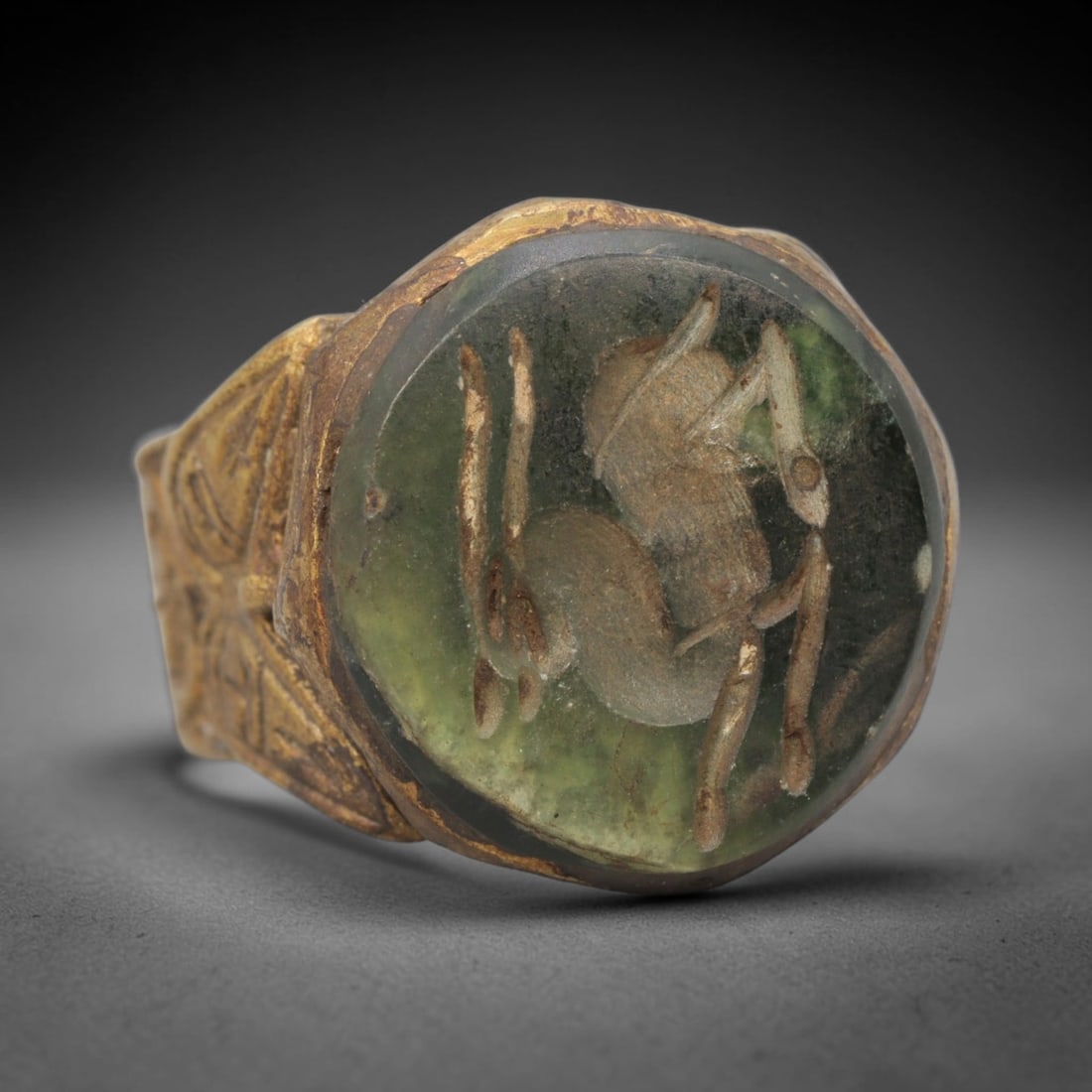 Antique Qajar Dynasty Scorpion Intaglio Ring - Size 9 US, 3WJ: Crafted from gilt brass with a faceted bezel, this ring features a carved green glass intaglio at its center, incised with a detailed scorpion motif-an amuletic symbol of protection in Persian antiqui