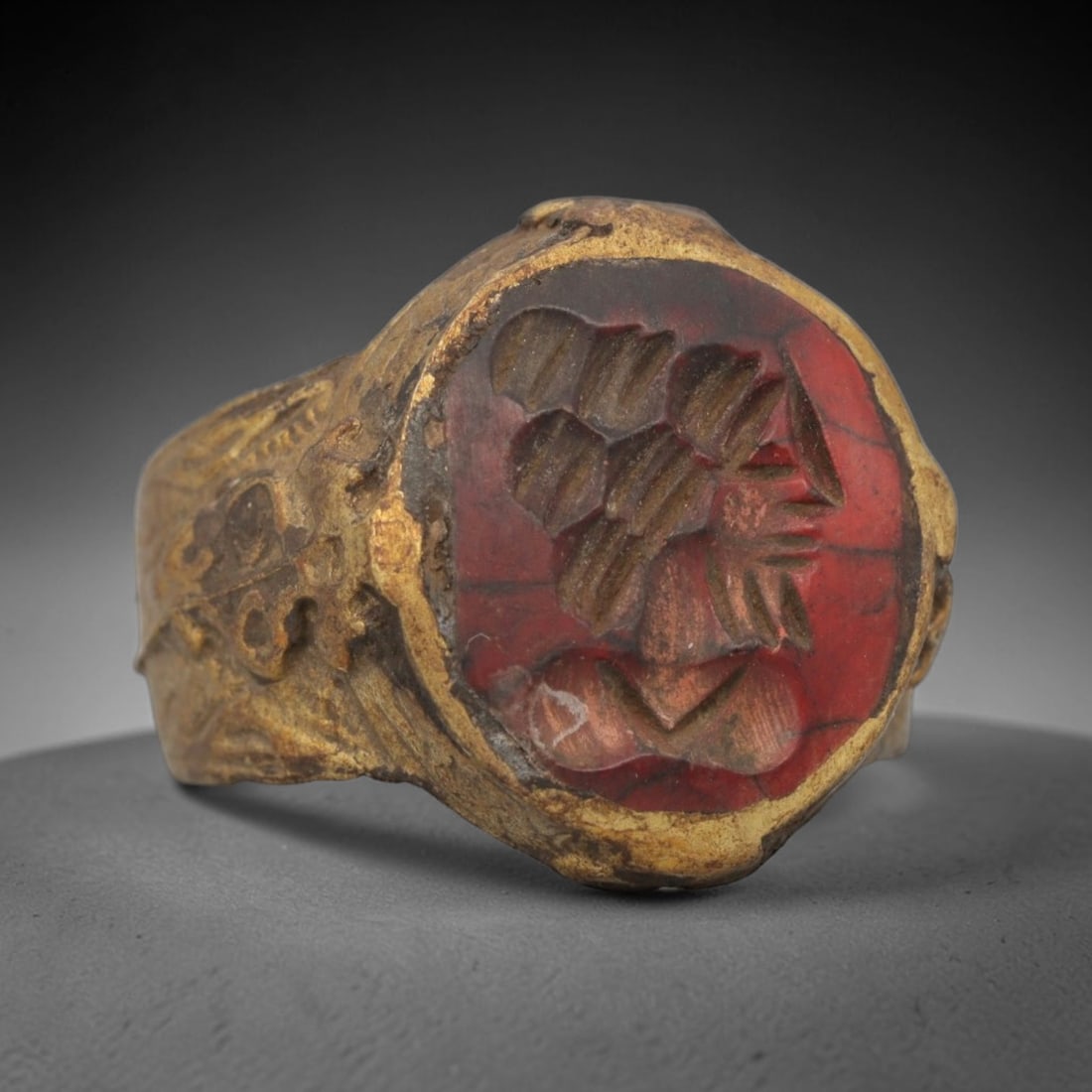 Antique Qajar Dynasty Carnelian Intaglio Ring - Size 9 US, 81ZX: Crafted from gilt metal with a rounded bezel, this ring features a carved carnelian intaglio stone at its center, depicting an incised profile motif with intricate linear detailing characteristic of Q