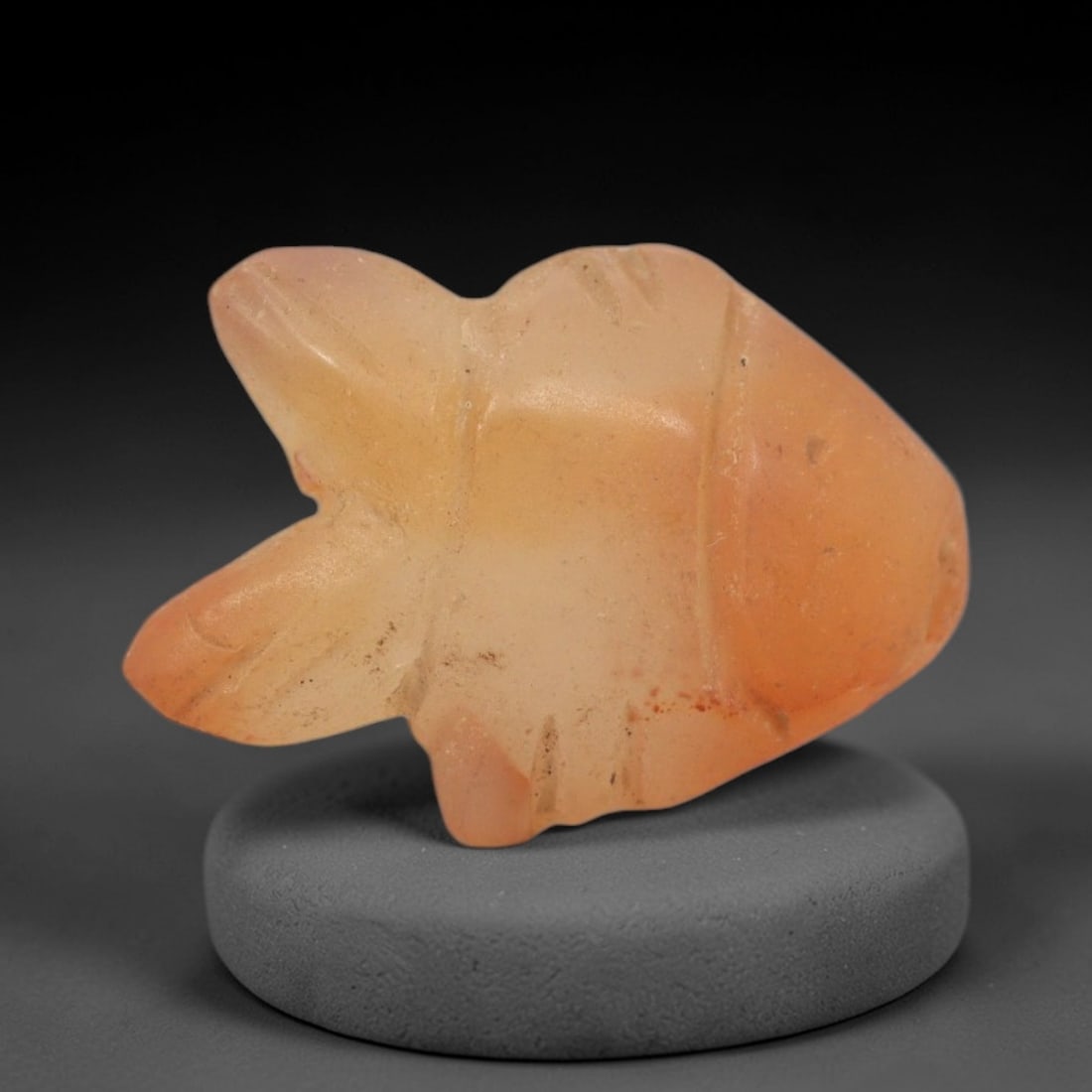 Ancient Carnelian Fish Amulet - Egyptian Figurine, 86XS: Carved from warm, translucent orange-red carnelian with natural tonal gradients and subtle surface patination, this amulet is formed as a stylized fish with incised linear detailing to define segmente