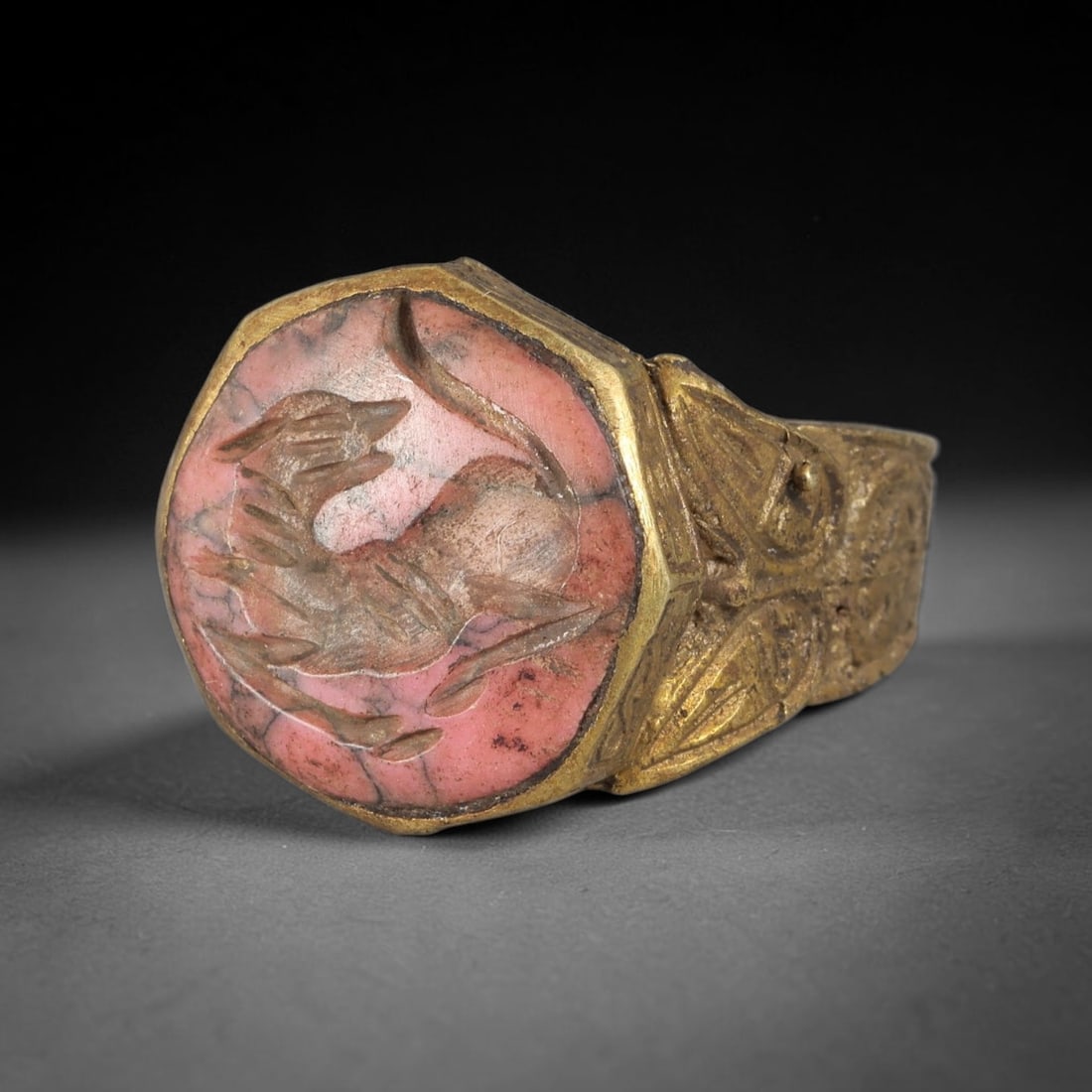 Antique Qajar Dynasty Rhodonite Feline Intaglio Ring - Size 9 US, 97FY: Crafted from gilt brass with a faceted octagonal bezel, this ring features a carved rhodonite intaglio stone at its center, incised with a detailed stylized feline (cat) motif-an amuletic symbol of pr