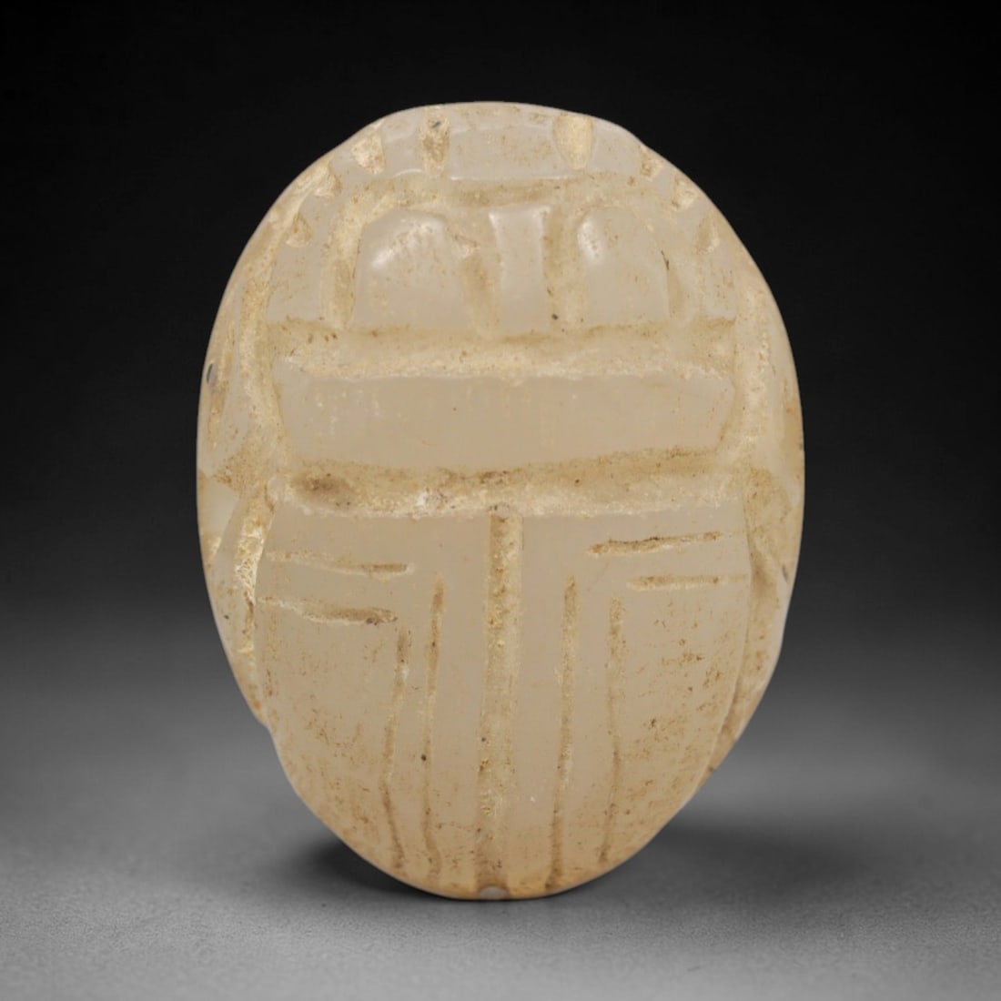Ancient Chalcedony Scarab - Egyptian Amulet Figurine, 86ZW: This amulet is carved from pale translucent chalcedony, shaped into the classic scarab beetle form, a symbol of rebirth and protection in ancient Egyptian cosmology. Detailed incised lines define the
