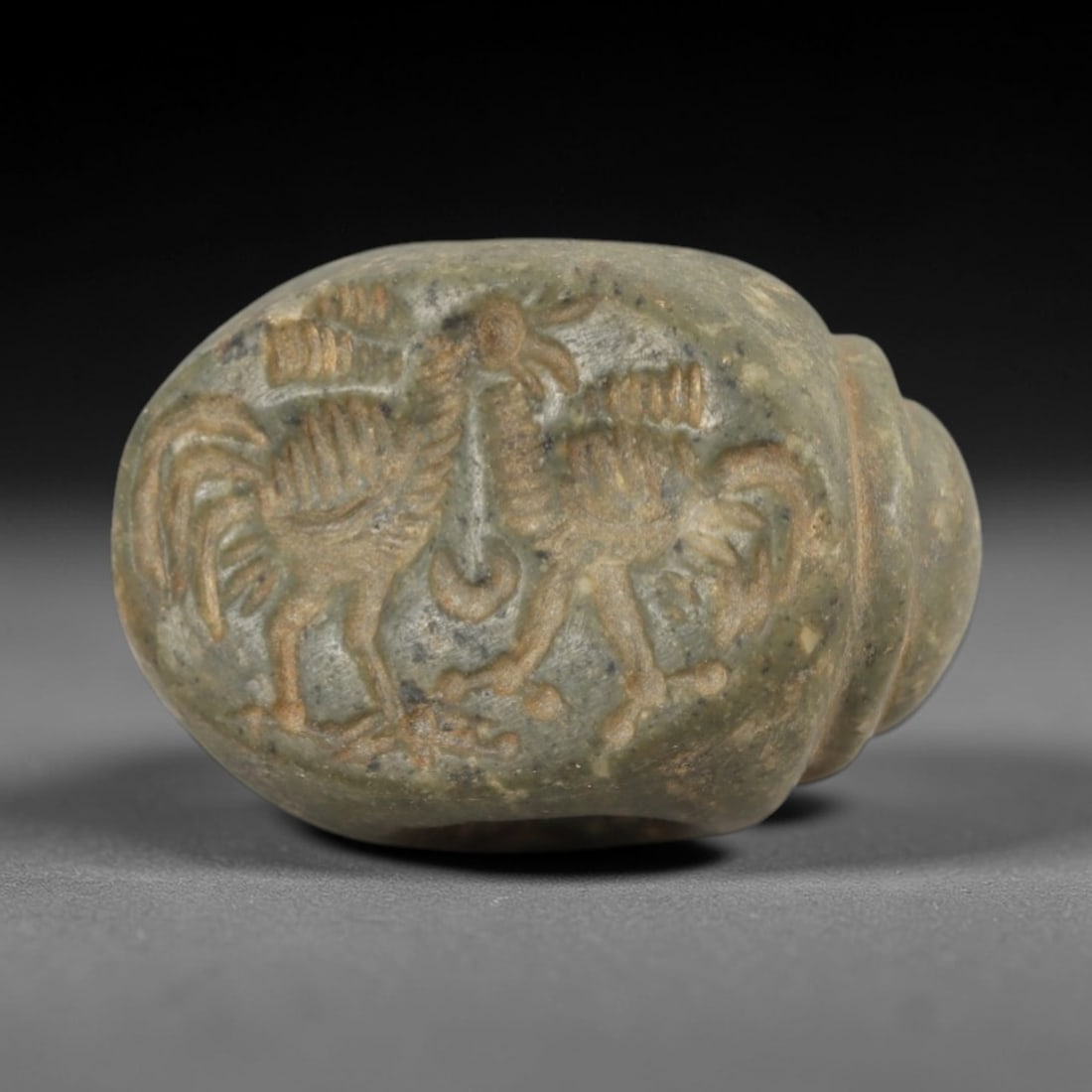 Ancient Steatite Stamp Seal - Sasanian Two Birds, 51AK: Carved from steatite, this hemispherical Sasanian stamp seal features a central composition of two stylized birds with incised details defining their crests, wings, and tails, consistent with Sasanian