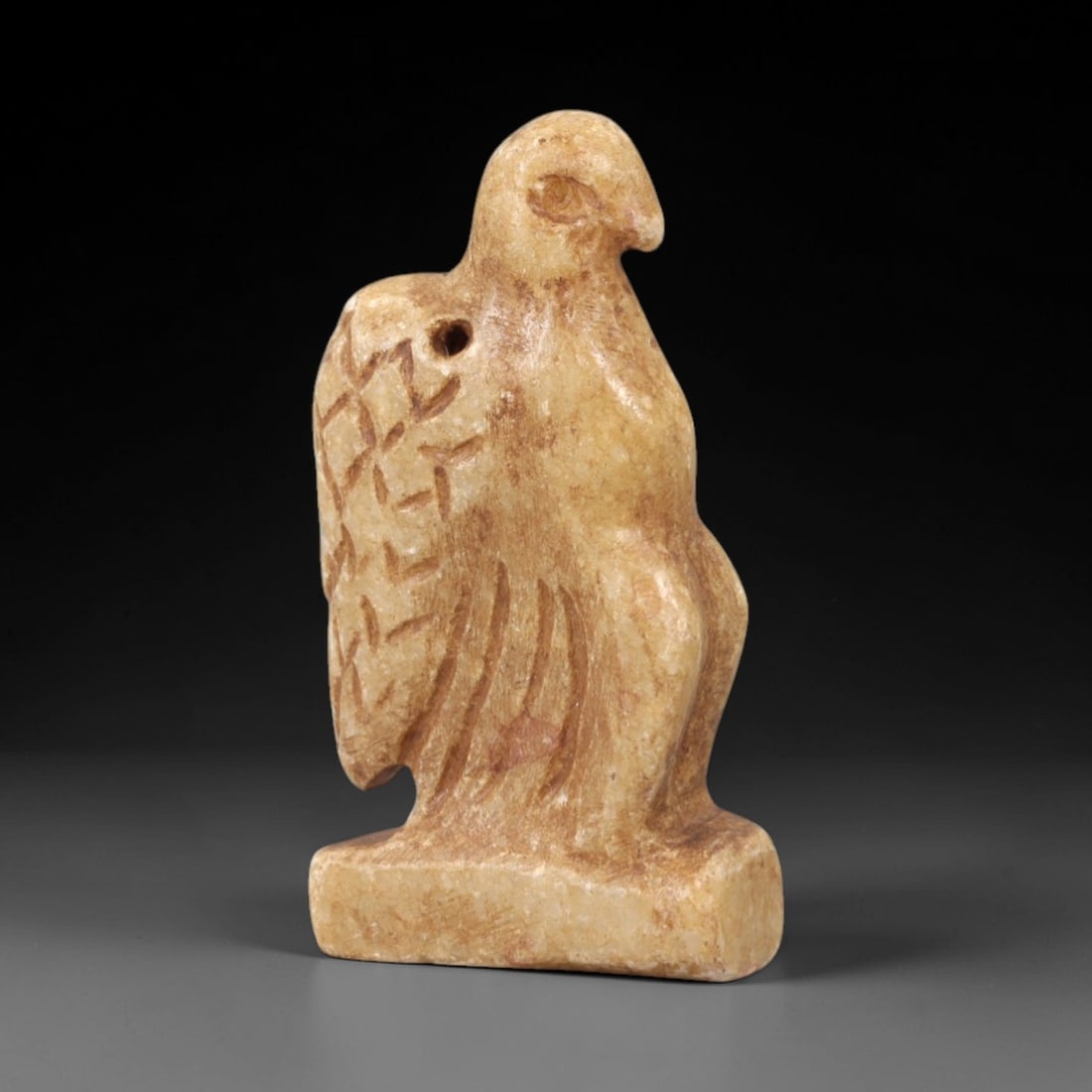 Ancient Steatite Vulture - Near Eastern Amulet Figurine, 96AK: Carved from steatite, this amulet depicts a stylized vulture in a perched stance, with incised linear details defining the wing feathers, body, and facial features including a defined eye and beak. A