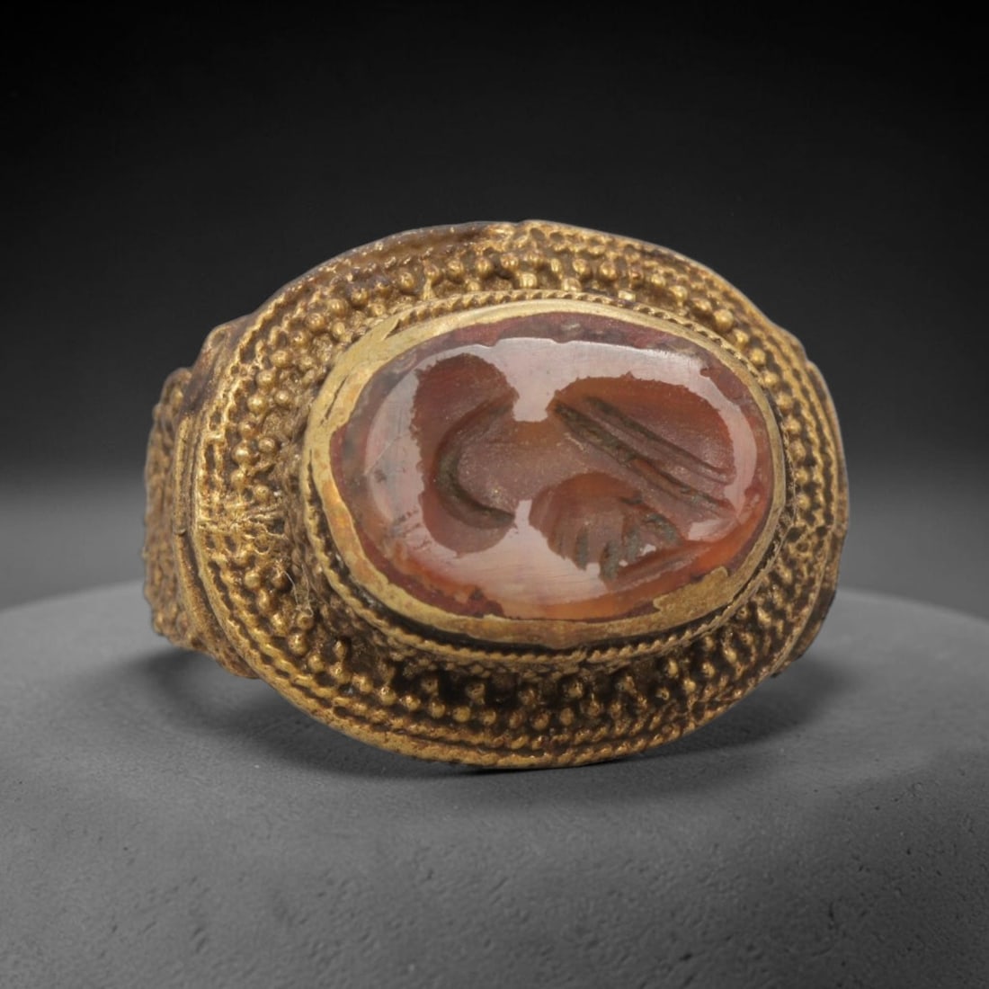 Antique Qajar Dynasty Brass Carnelian Intaglio Ring - Size 9 US, 70ZX: This antique Qajar dynasty brass intaglio ring features an oval carnelian intaglio inset with incised figural carvings, set within an ornate brass mount adorned with layered granular beading and decor