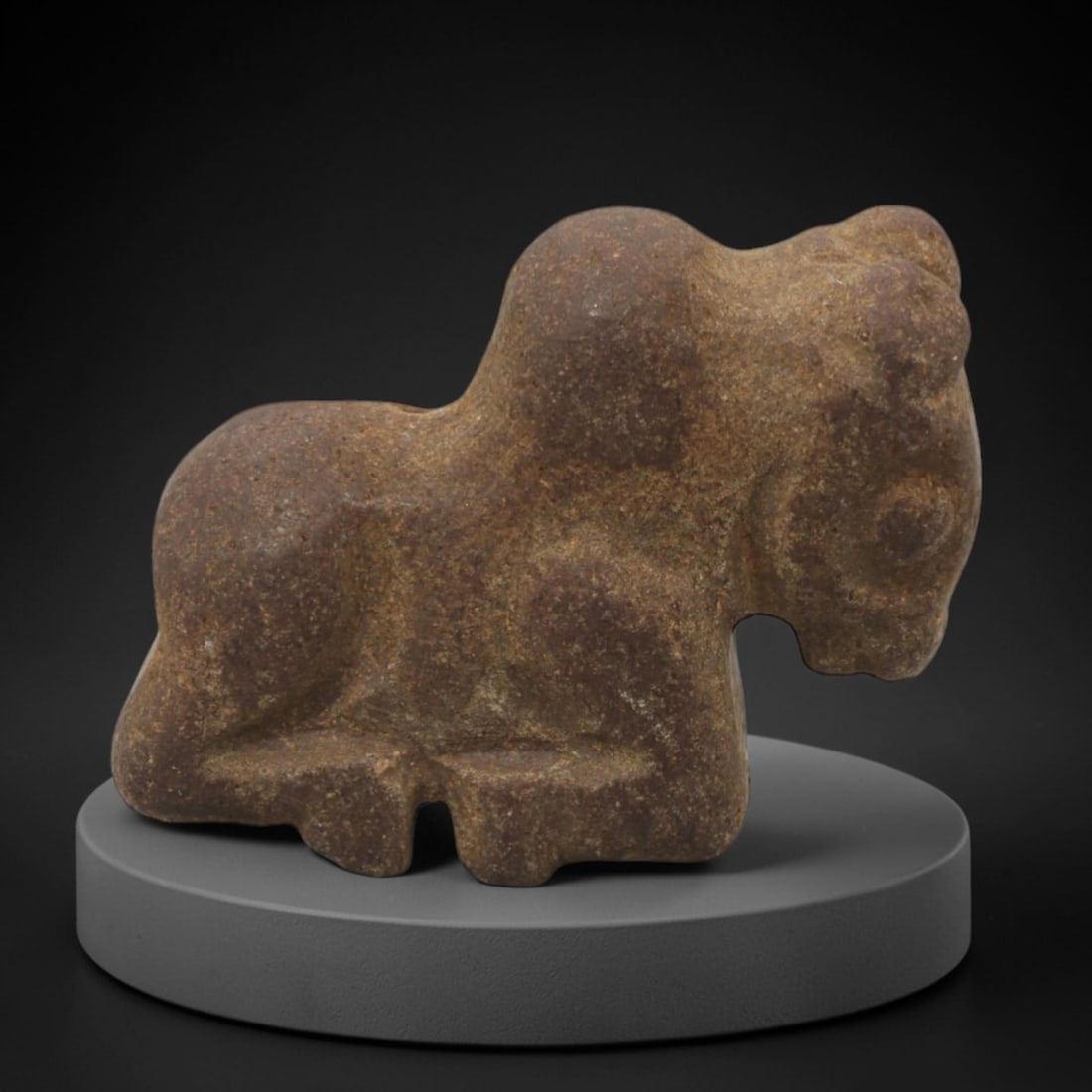 Ancient Stone Bovid - Near Eastern Amulet Figurine, 45XR: Carved from reddish-brown stone, this amulet depicts a recumbent bovid with a prominent hump, stylized facial features, and compact, rounded limbs. The form and iconography are characteristic of Ancie