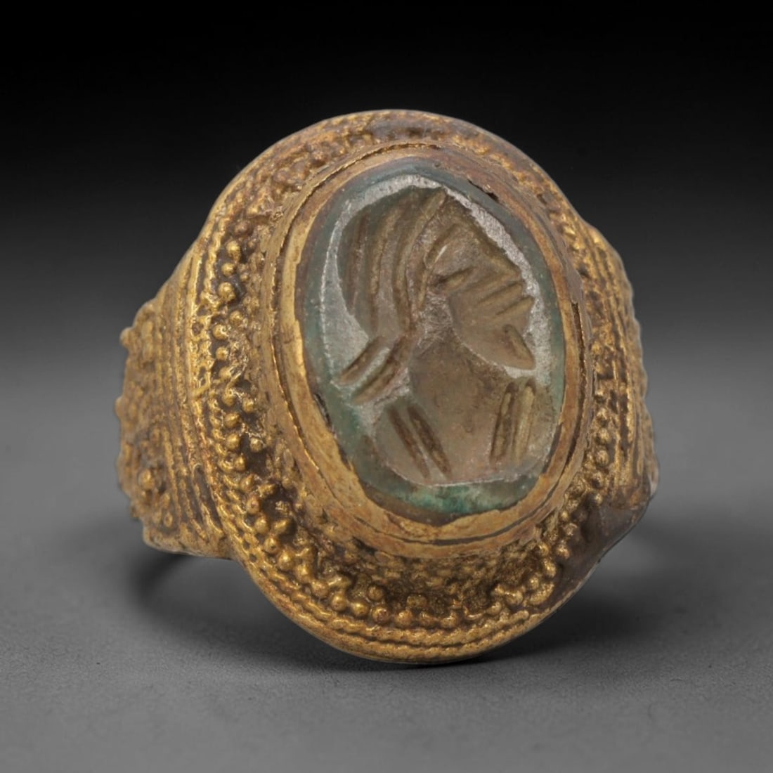 Antique Qajar Dynasty Brass Intaglio Ring - Size 8 US, 67ZX: This antique Qajar dynasty brass intaglio ring features an oval hardstone intaglio inset carved with a detailed profile portrait, set within an ornate brass mount adorned with layered granular beading