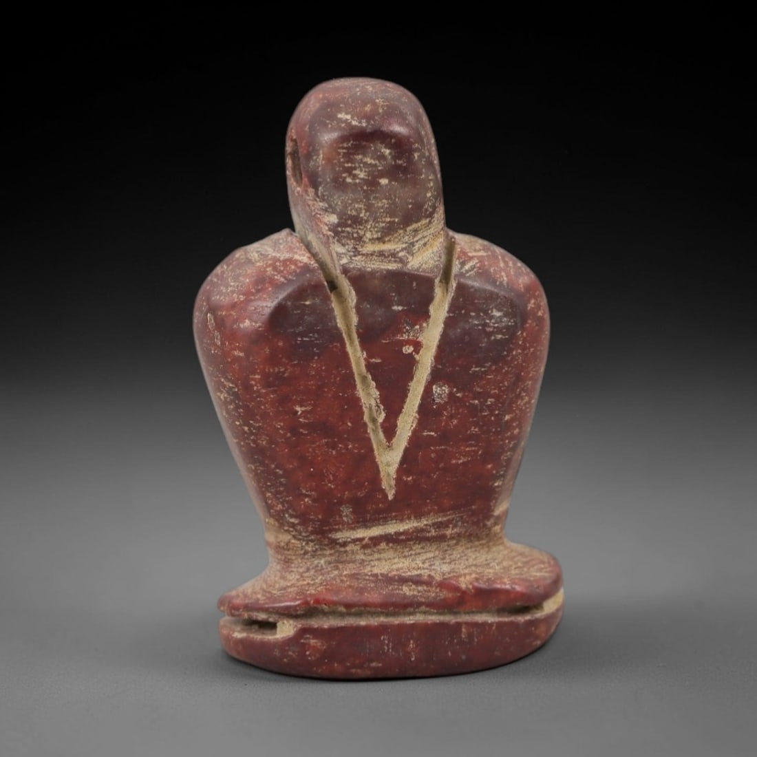 Ancient Red Stone Idol Amulet - Egyptian Style Figurine, 93AE: Carved from red stone, this ancient Egyptian-style idol features a compact, stylized humanoid form with defined facial and body details and a suspension hole at the top, indicating its use as a wearab
