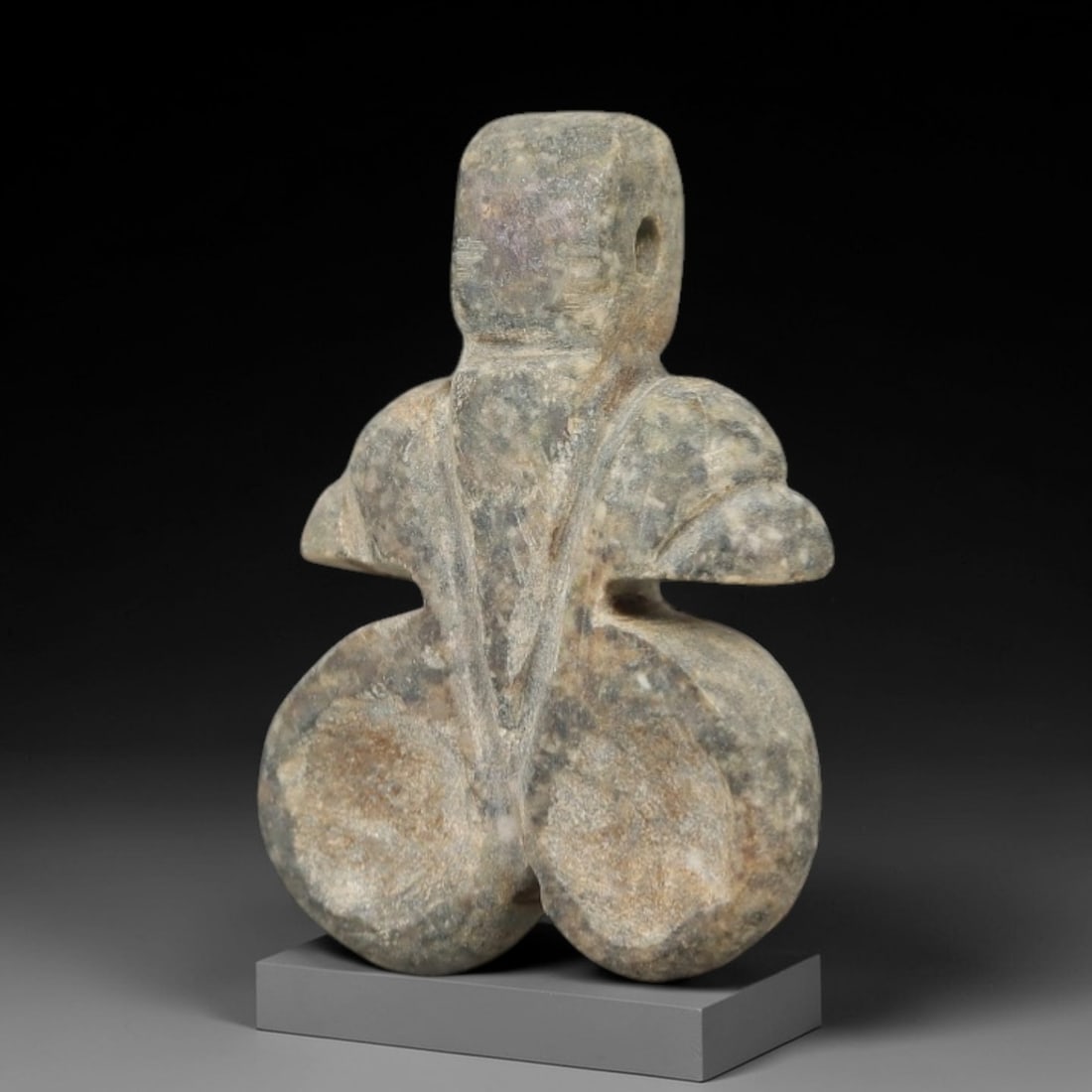Ancient Stone Double-Bodied Amulet - Near Eastern Figurine, 35AG: This artifact is a carved stone amulet of Near Eastern origin, fashioned from a mottled gray-green stone with natural mineral veining. Its abstract form consists of a rectangular upper segment with a