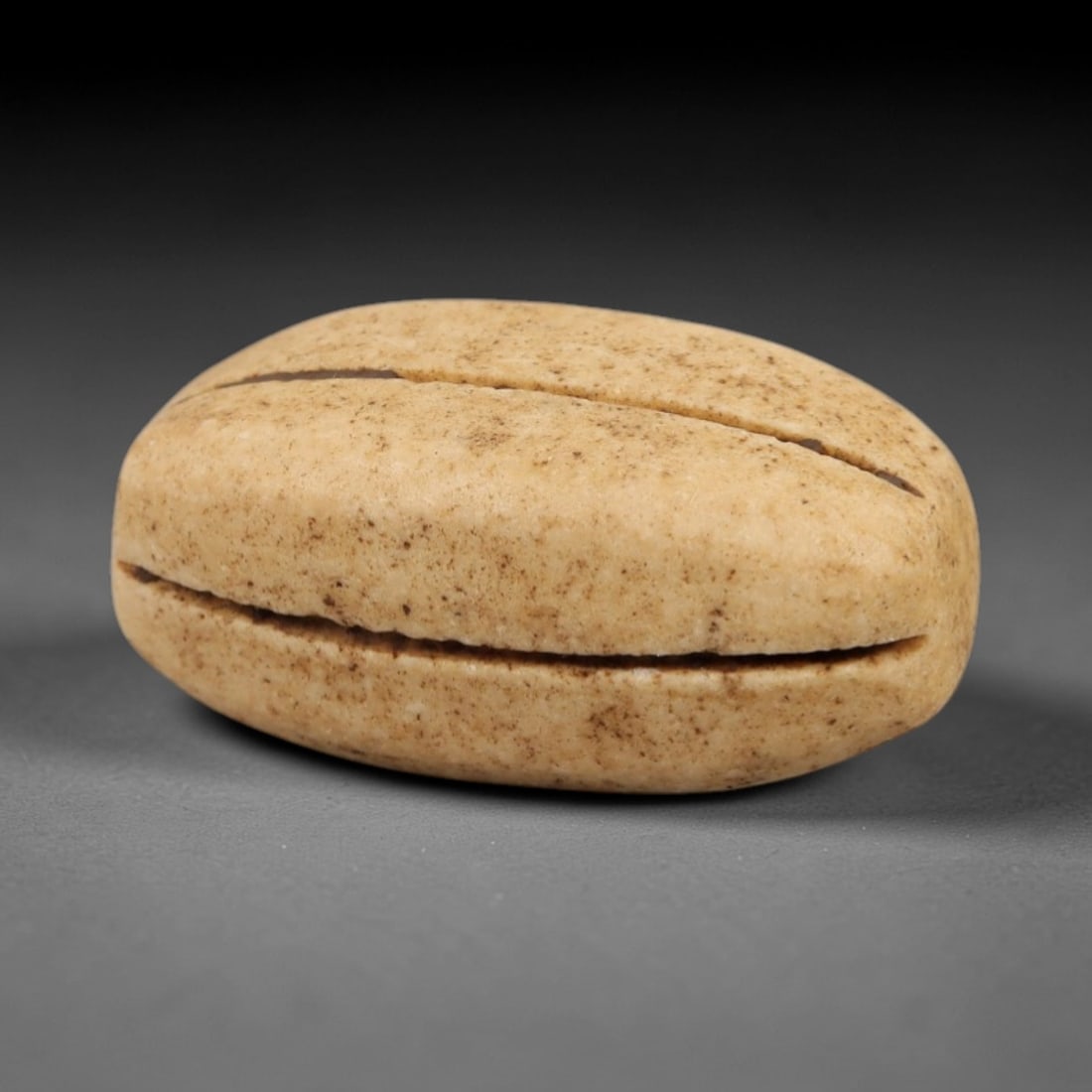 Ancient Egyptian Stone Bead - Parallel Line Carving, 5AG: Carved from stone, this ancient Egyptian bead features parallel linear patterns on its surface, a common decorative technique in Egyptian beadwork from the Late Period. The compact form has a central