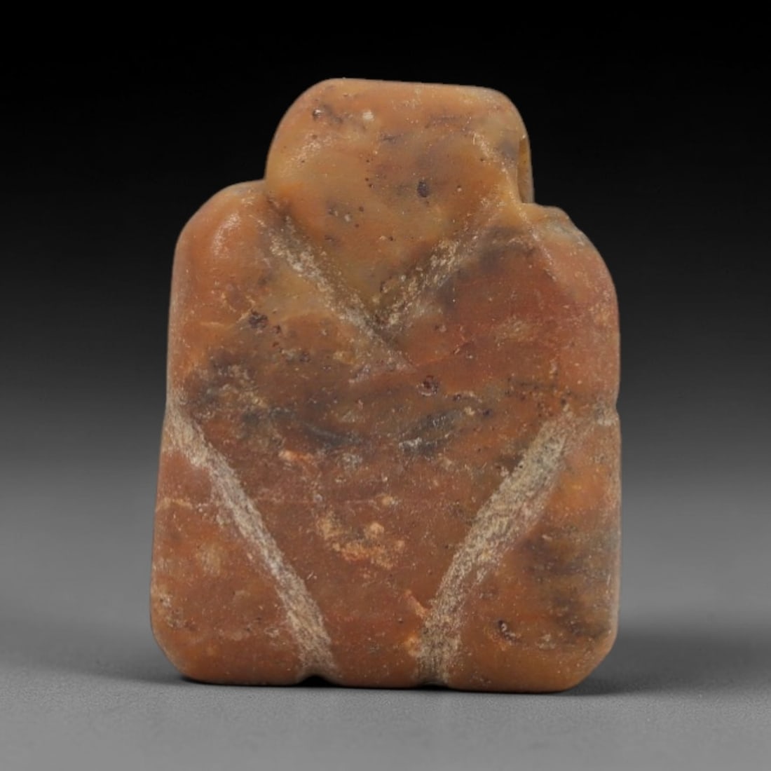 Ancient Stone Eye Idol - Near Eastern Figurine, 22AJ: Carved from a warm orange-brown stone, this amulet takes a simplified rectangular form with incised linear markings forming a stylized eye motif across the front, consistent with ancient Near Eastern