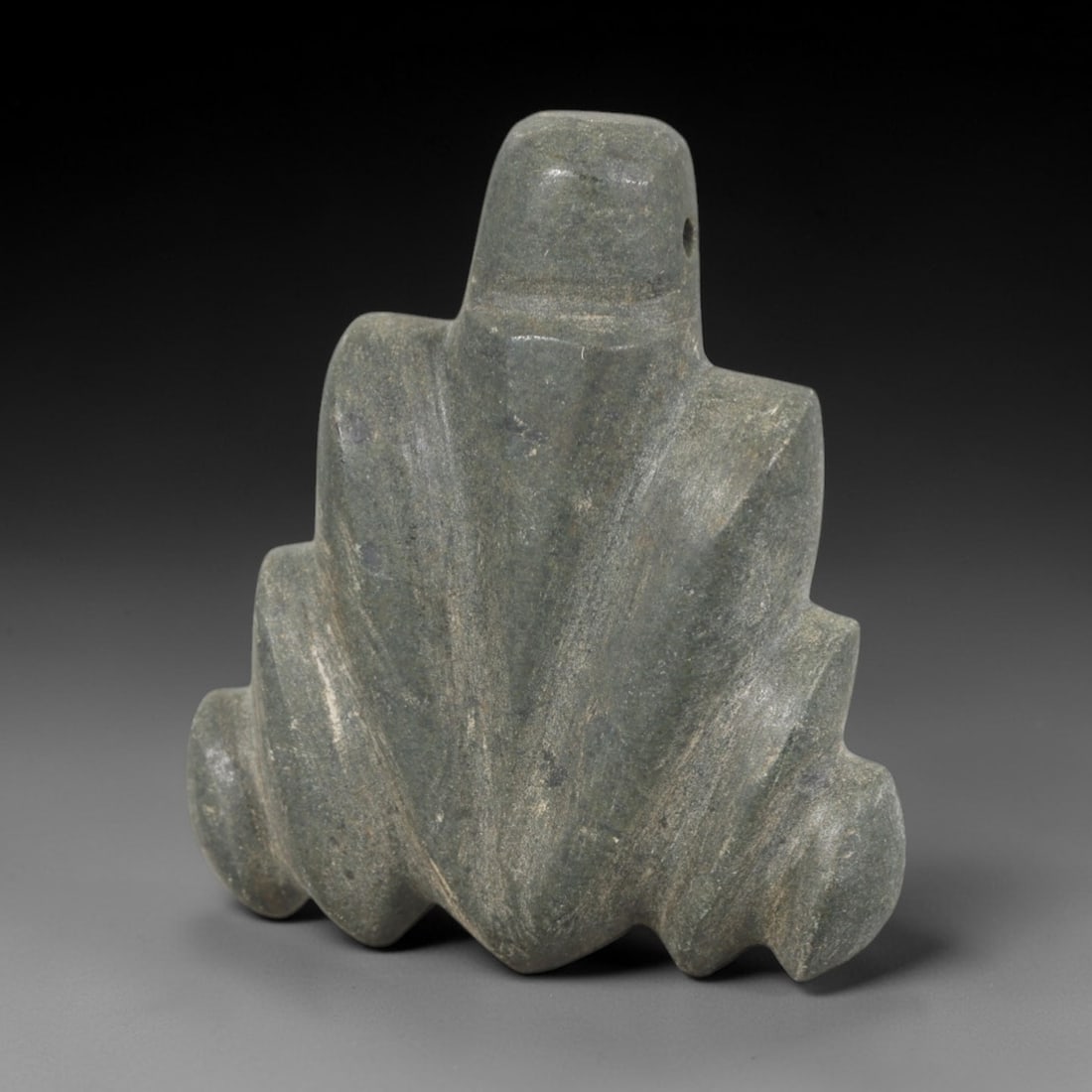 Ancient Green Stone Lotus Amulet - Near Eastern Pendant, 27AR: This artifact is carved from a mottled green stone, exhibiting a weathered, matte finish with subtle mineral variations and faint surface wear consistent with age. The form is a stylized lotus amulet,