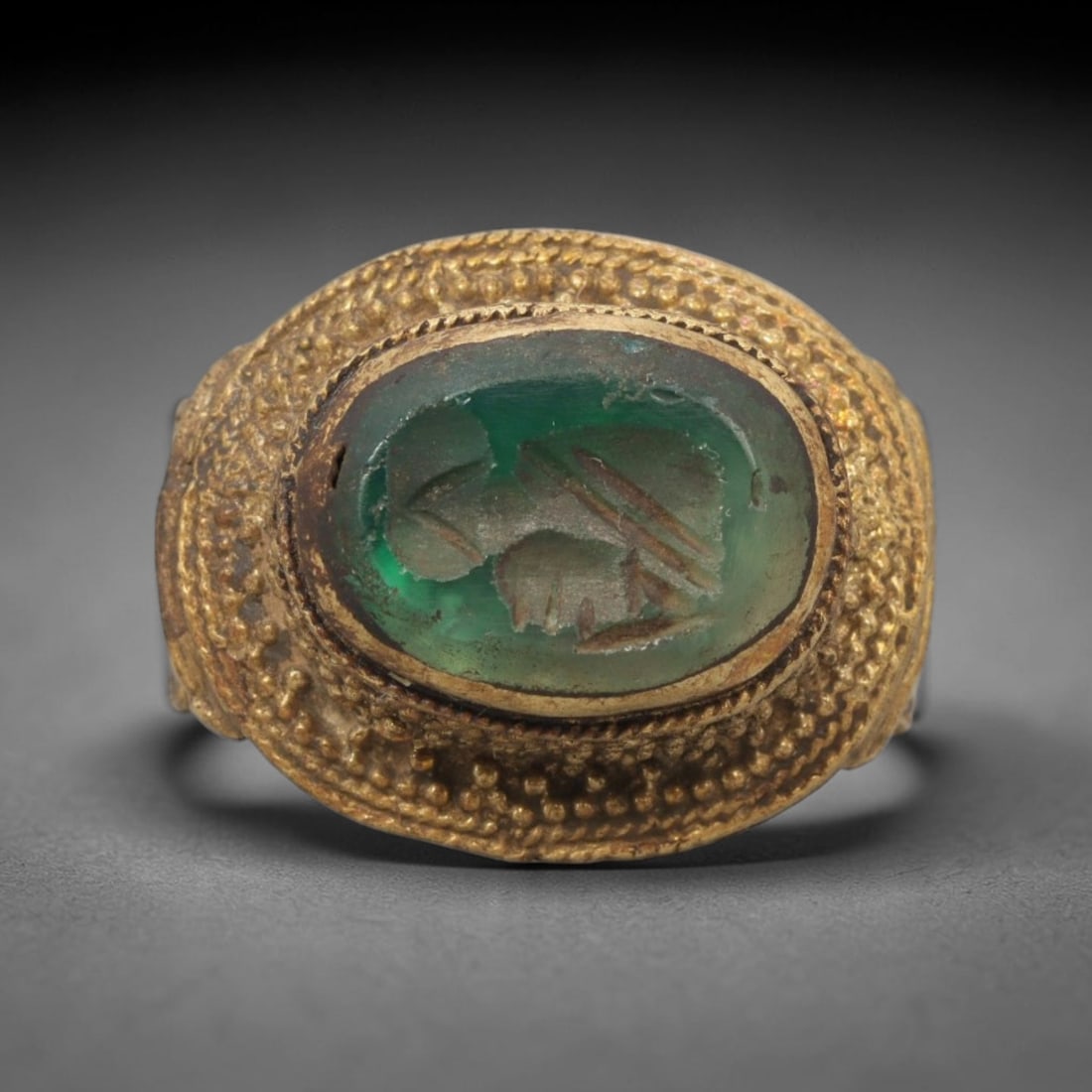 Antique Qajar Dynasty Brass Green Stone Intaglio Ring - Size 8 US, 98ZX: This antique Qajar dynasty brass intaglio ring features an oval green stone intaglio inset with incised figural carvings, set within an ornate brass mount adorned with layered granular beading and dec