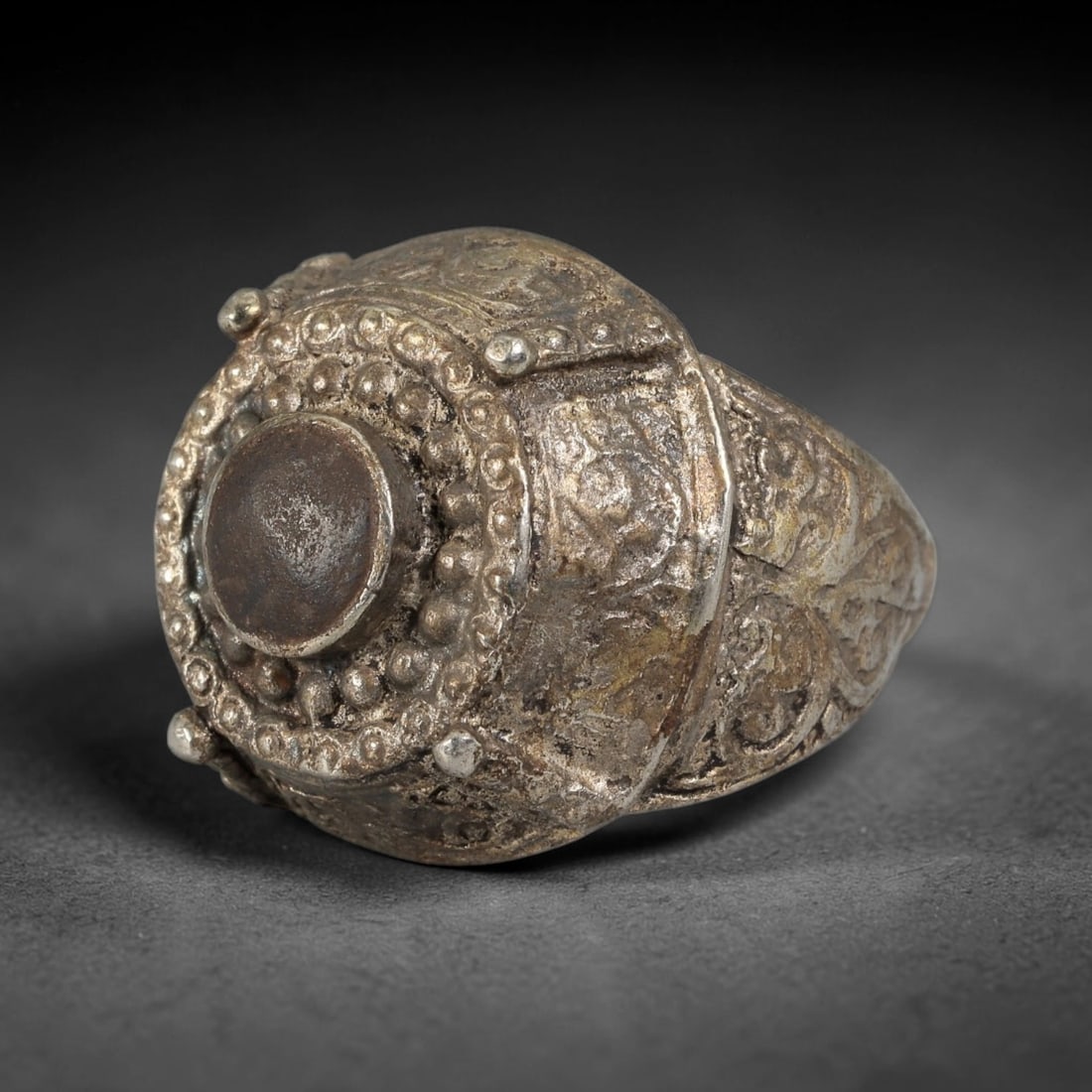Antique Qajar Dynasty Silvered Dome Ring - US Size 9, 83BA: This antique ring, crafted during the Qajar Dynasty of Persia, features a striking domed bezel with a central empty setting, surrounded by intricate beaded and granulated detailing. The shoulders of t