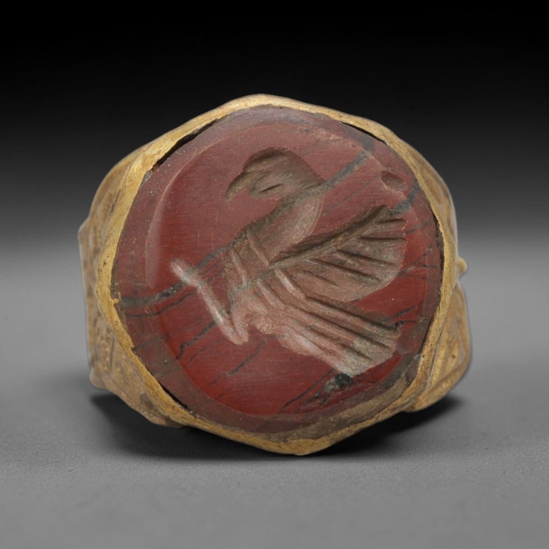 Antique Qajar Dynasty Brass Carnelian Intaglio Ring - Size 9 US, 11WJ: This antique Qajar dynasty brass intaglio ring features an octagonal carnelian intaglio inset carved with a detailed eagle motif, set within an ornate brass mount. The ring is crafted from brass, with