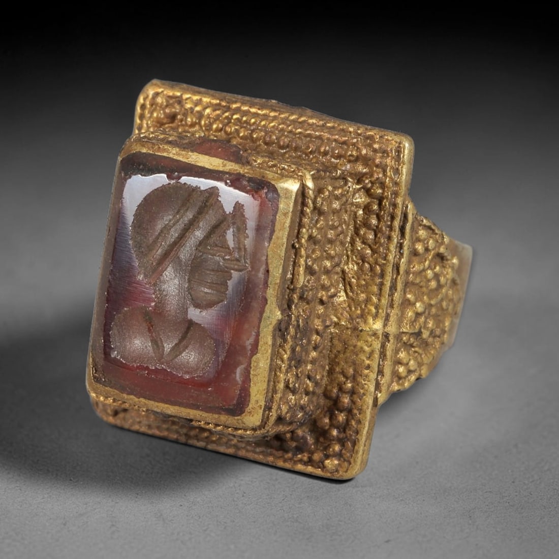 Antique Qajar Dynasty Brass Intaglio Ring - Size 8 US, 72BA: Crafted from brass, this ring features a square-set carnelian intaglio panel carved with a profile figure, executed in the distinctive Qajar style. The brass band exhibits a textured, granular granula