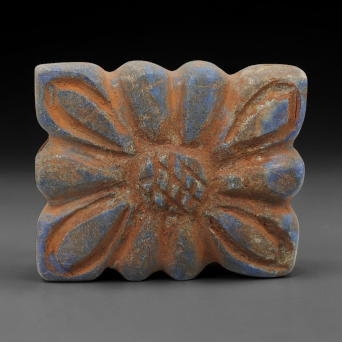 Ancient Lapis Lazuli Bead - Achaemenid Amulet, 11ZQ: Carved from deep blue lapis lazuli, this bead features a floral motif with incised detailing. The stone exhibits natural pyrite inclusions and a subtle, aged patina consistent with Achaemenid period l