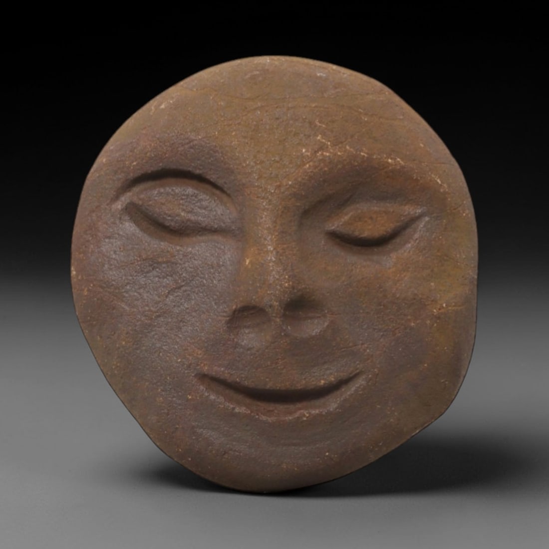 Ancient Stone Anthropomorphic Mask - Tribal Ritual Relic, 77FW: Carved from a dense, earthy-brown stone with subtle textural variations and fine crack lines, this artifact presents a rounded anthropomorphic mask featuring delicately incised closed eyes with soft b