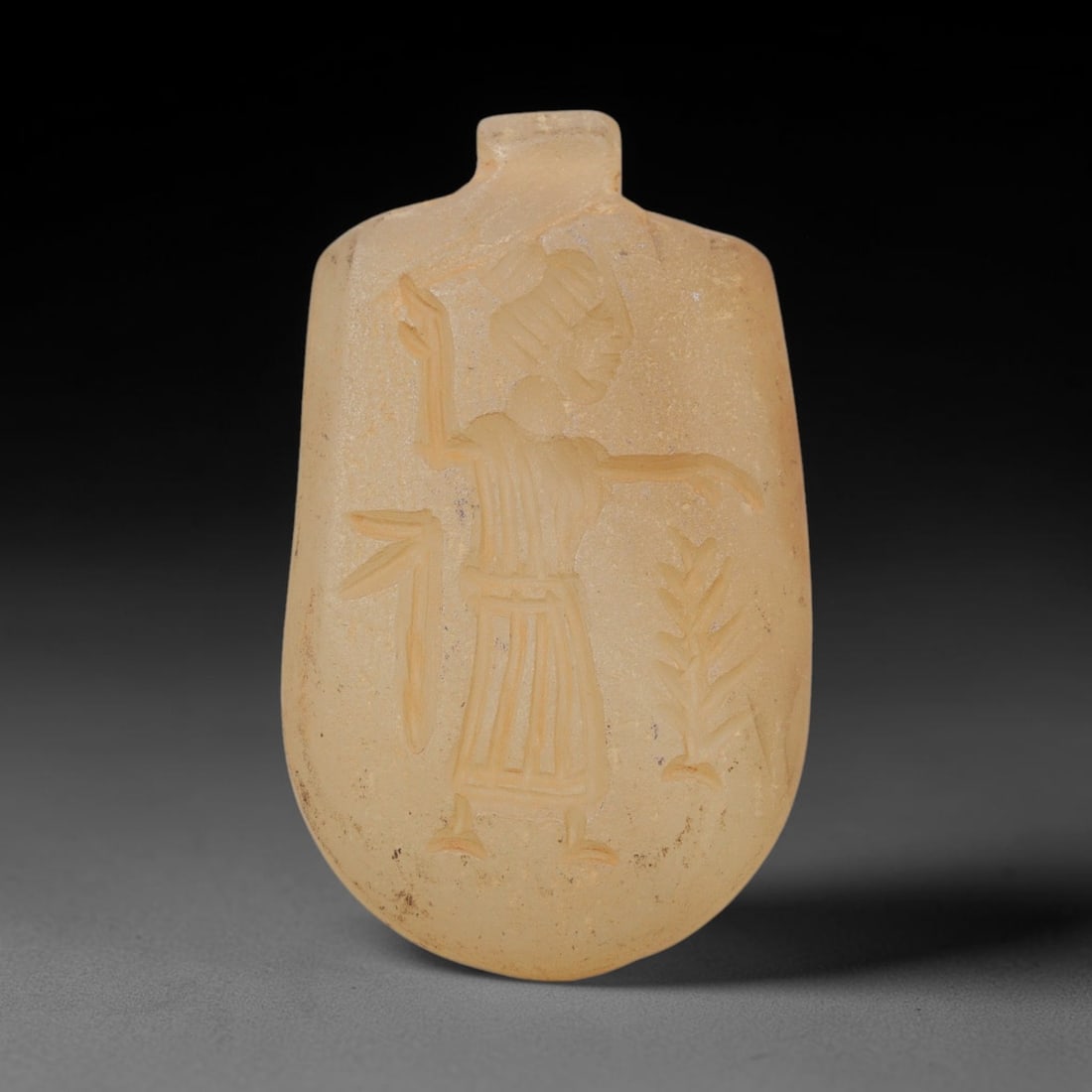 Ancient Chalcedony Plaque - Near Eastern Amulet Relief, 31WJ: Carved from chalcedony, this ancient Near Eastern amulet plaque features a finely incised relief of a standing anthropomorphic figure, rendered with precise linear carvings that define the figure's he